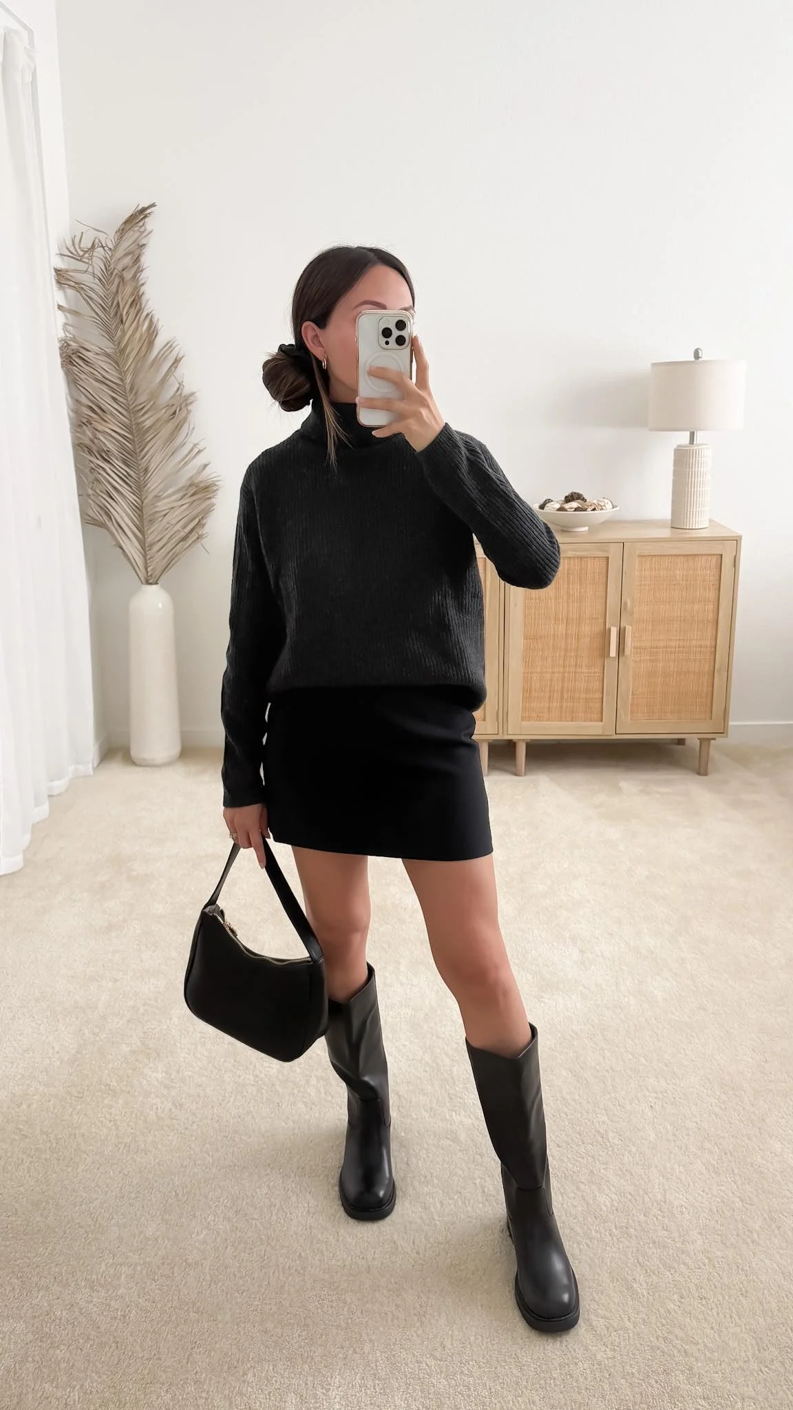Sweater outfit with mini skirt featuring the Quince Mongolian Cashmere Fisherman Turtleneck Sweater styled with a black mini skirt, knee-high leather boots, and black shoulder bag