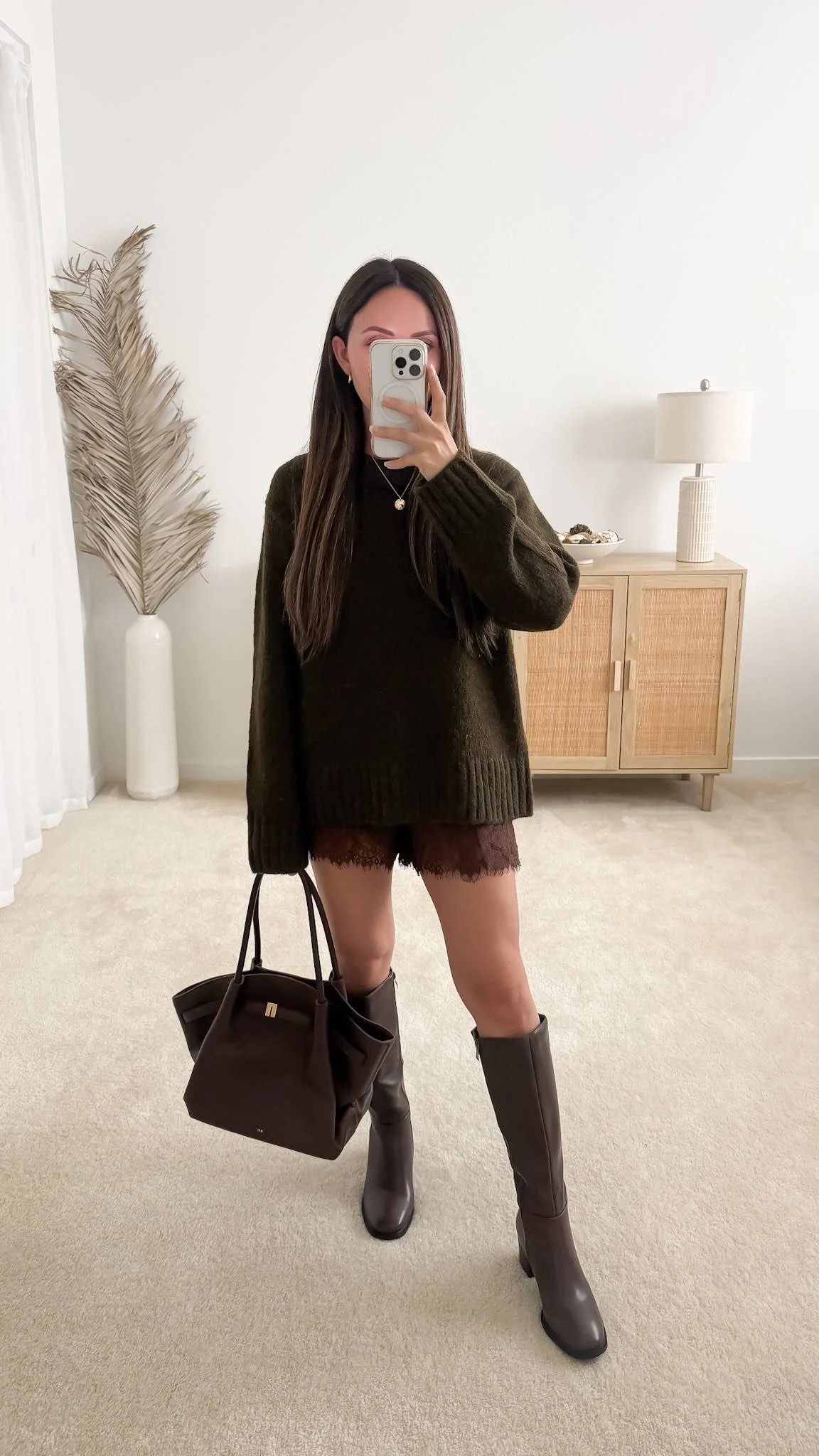 Sweater with satin lace shorts outfit featuring the Quince Lofty Baby Alpaca Oversized Crew Sweater styled with brown lace shorts, knee-high boots, and a brown handbag