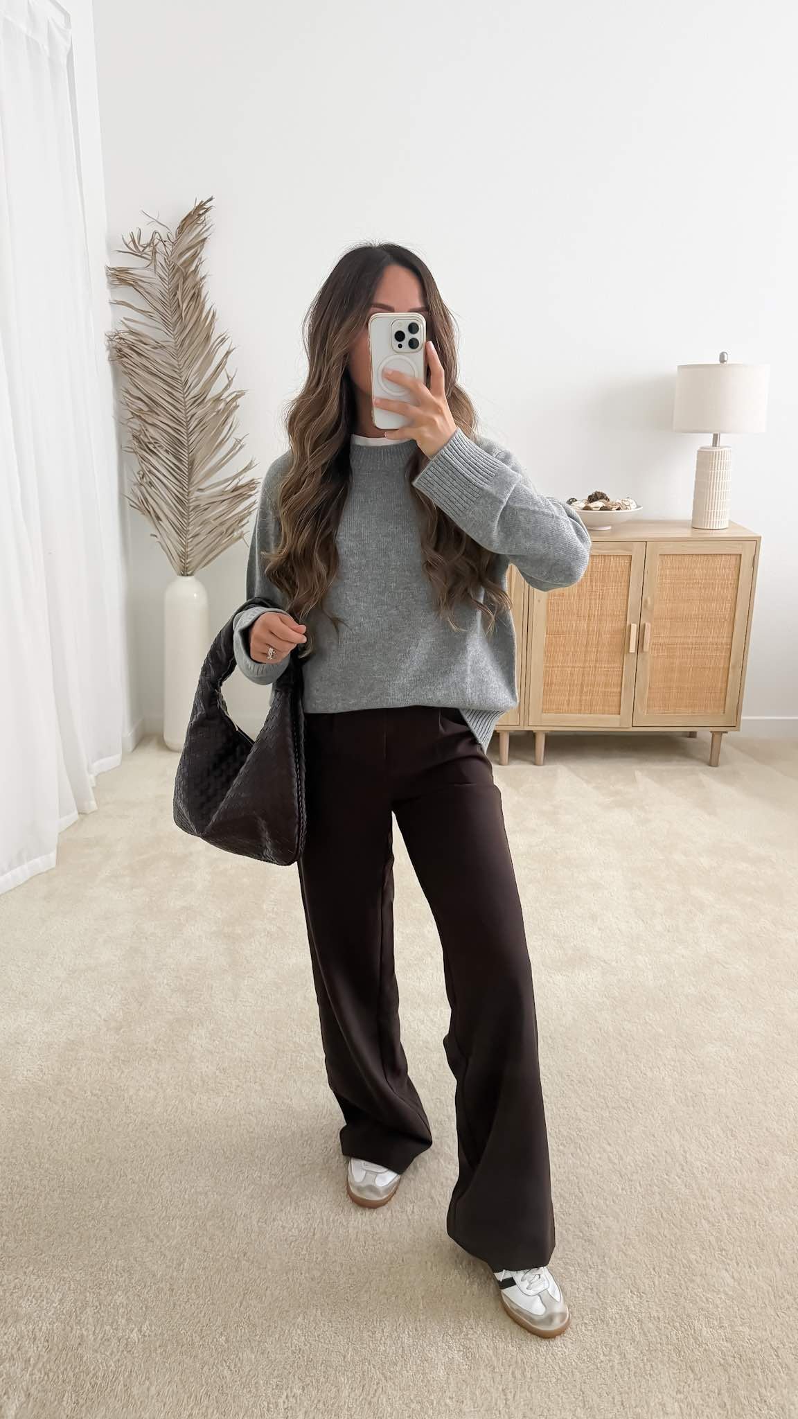 Fall outfit with oversized gray sweater, dark brown wide-leg pants, sneakers and brown woven bag