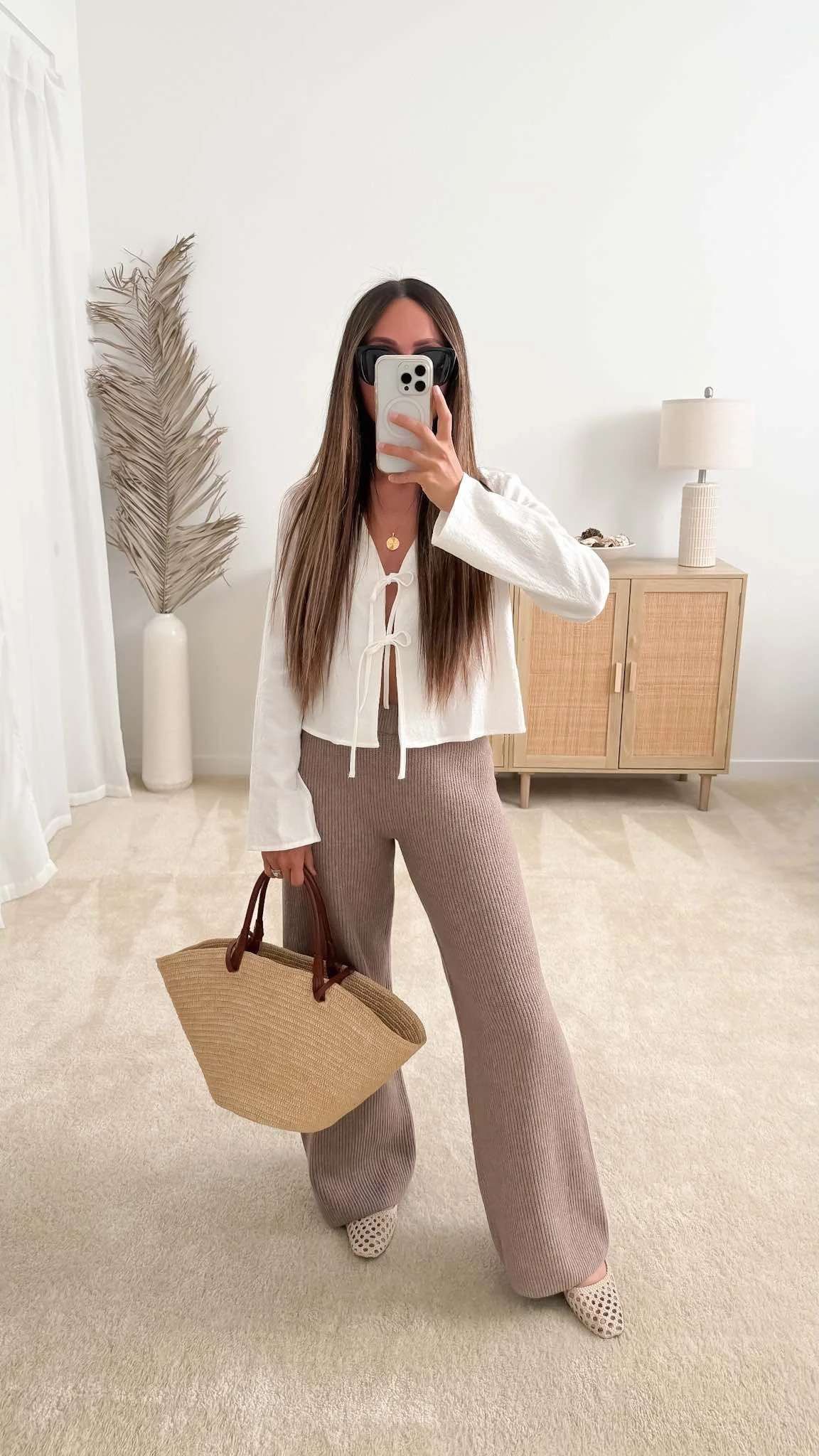 A minimalist spring capsule outfit featuring a white tie-front top, cream ribbed pants, and Sézane Basket Bag styled by Neutrally Nicole