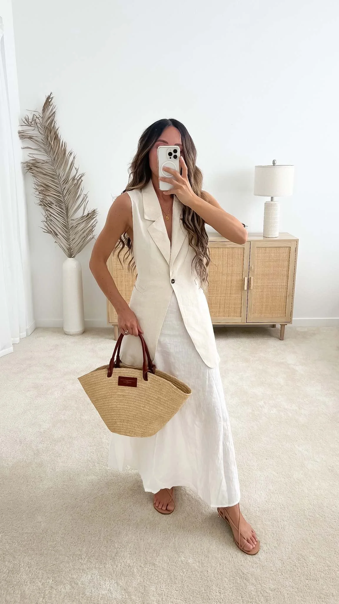 Nicole of Neutrally Nicole wearing a monochromatic summer capsule outfit with a cream linen vest, white maxi skirt, and Sézane basket bag