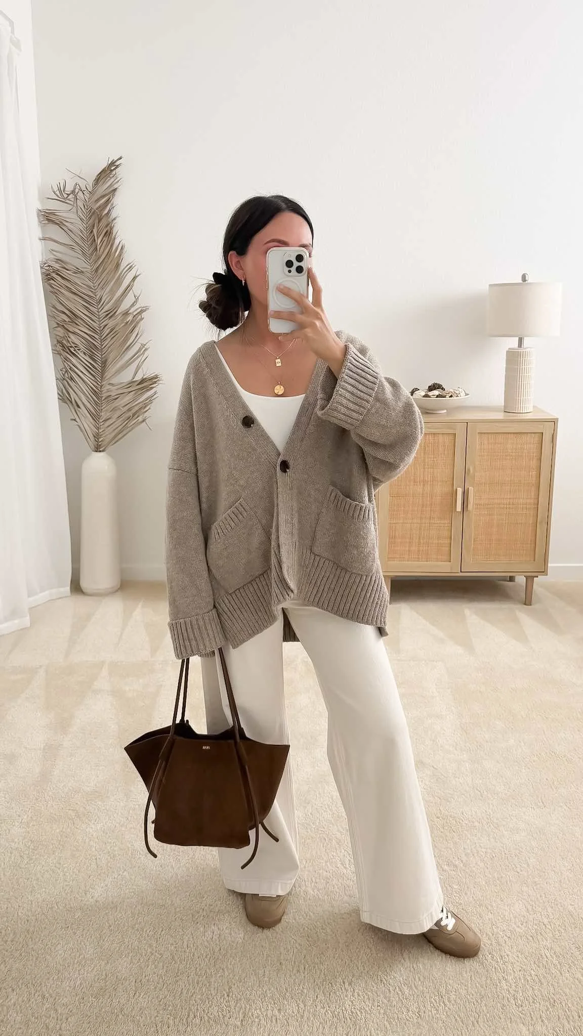 Neutral fall outfit with taupe cardigan, white jeans, brown suede bag and sneakers