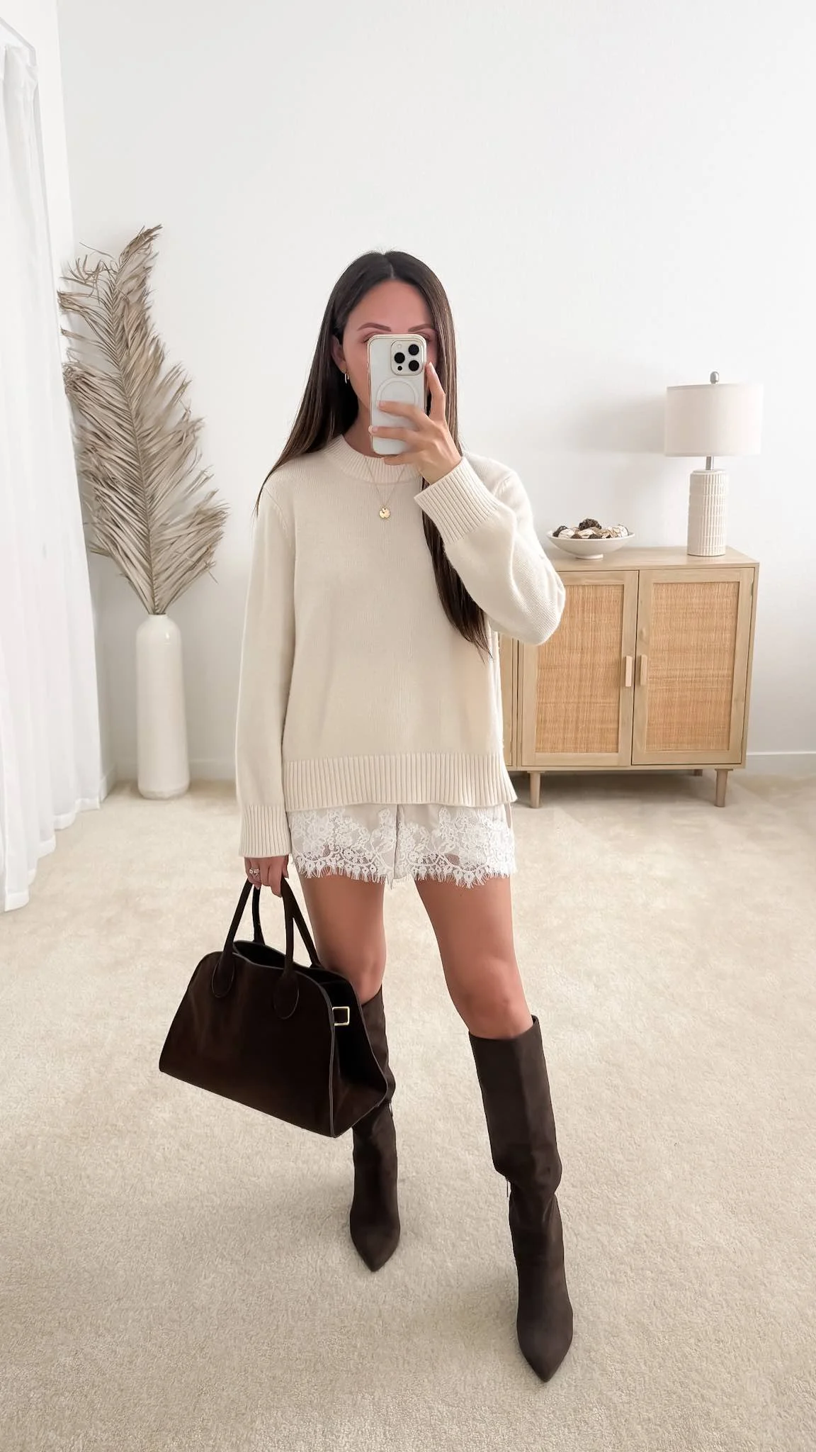 Sweater with satin lace shorts outfit featuring Quince Mongolian Cashmere Oversized Crewneck Sweater styled with satin lace shorts, brown knee-high boots, and a brown handbag