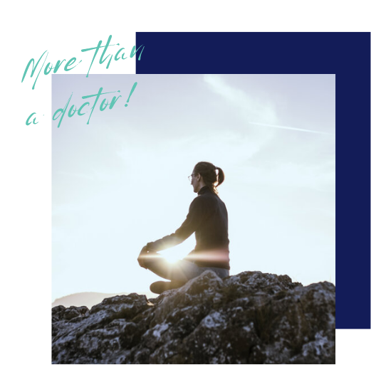 A person meditating on a rocky hilltop during sunrise or sunset with clouds in the sky and sunlight shining around them.