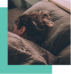 Person sleeping on a bed with their head resting on a pillow