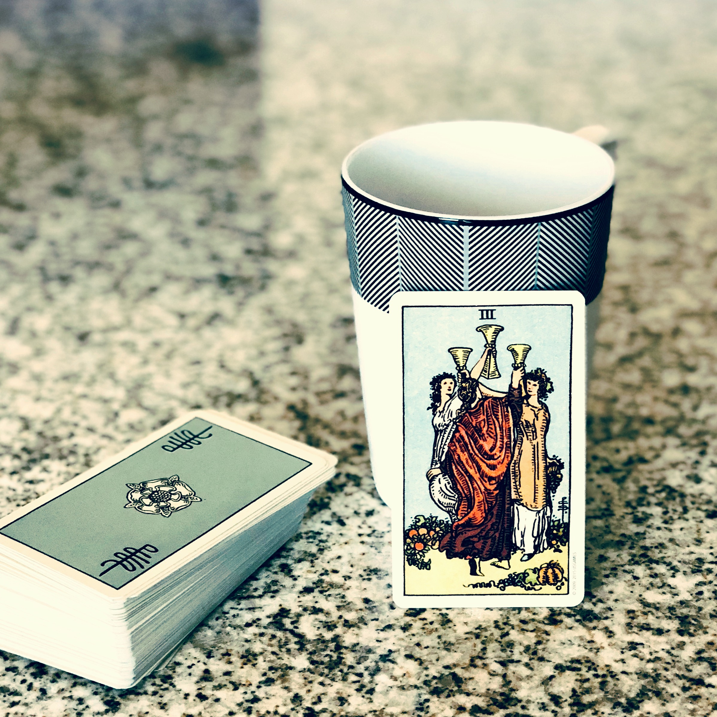 The 3 of Cups shows the celebration of three friends.