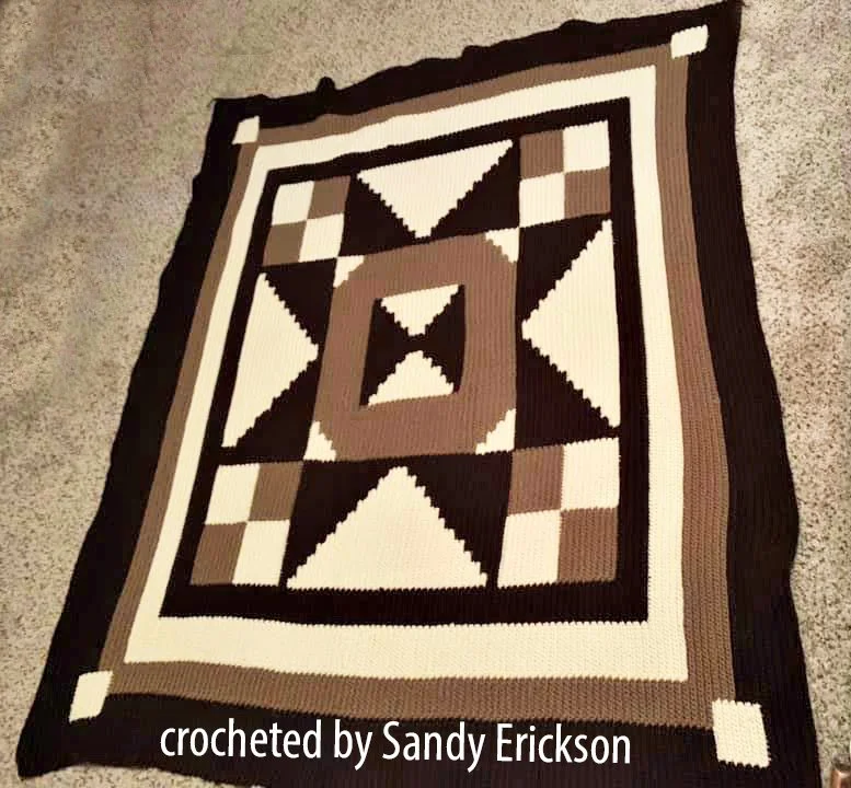 A crochet afghan inspired by traditional quilt patterns, featuring geometric shapes in warm brown tones, perfect for cozy home décor or gifting.