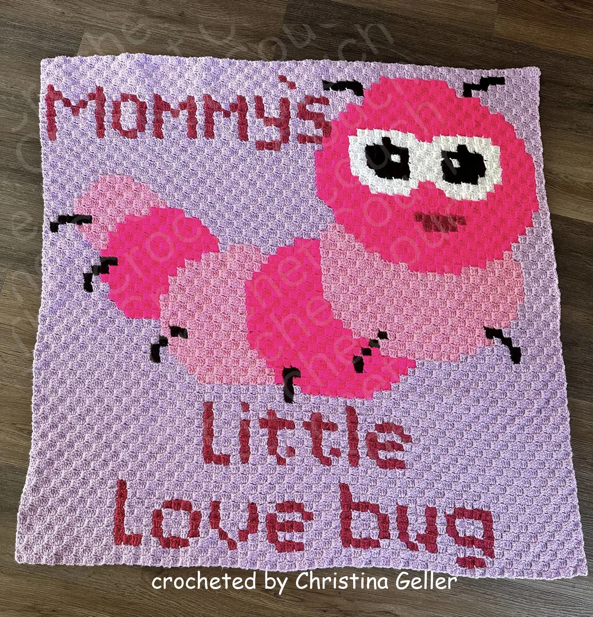 Crochet blanket with a cute caterpillar and "Mommy's Little Love Bug" text in pink tones.