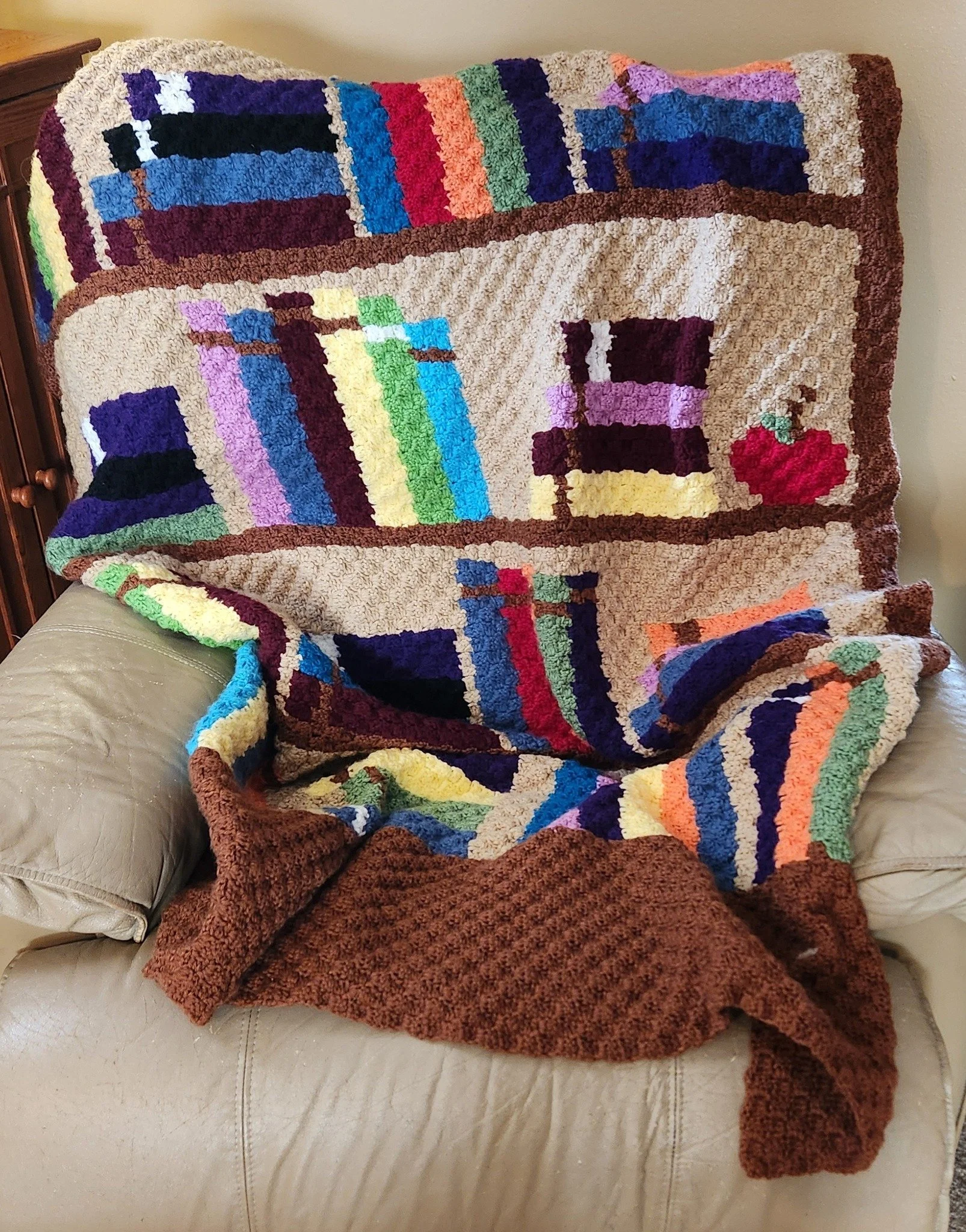 Bookcase afghan draped over a chair, crocheted by Sharon Langlotz, done in a variety of colors