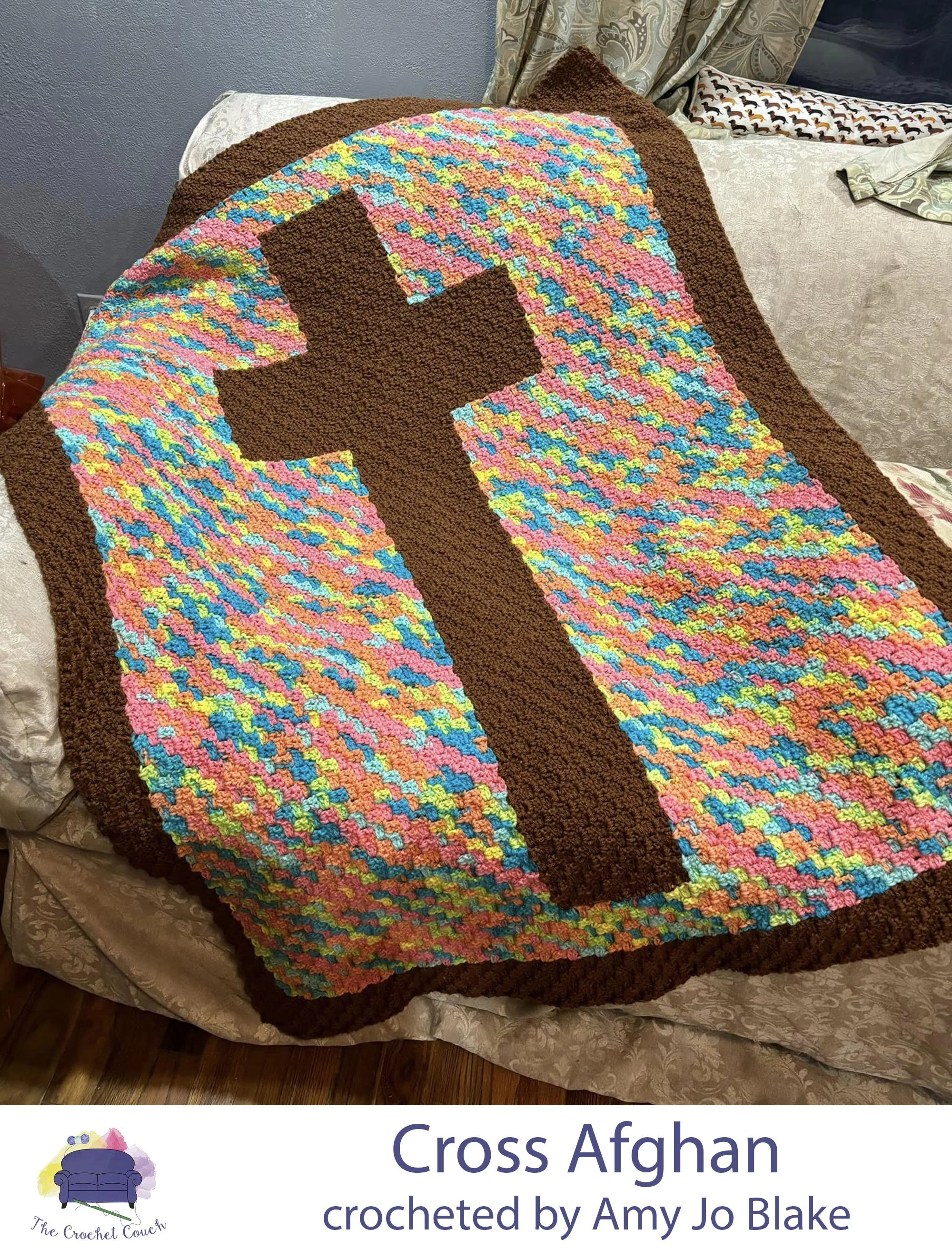 Cross afghan crocheted using the C2C technique. Afghan is draped over a couch. The cross and border are brown and the background is a multi color variegated yarn.