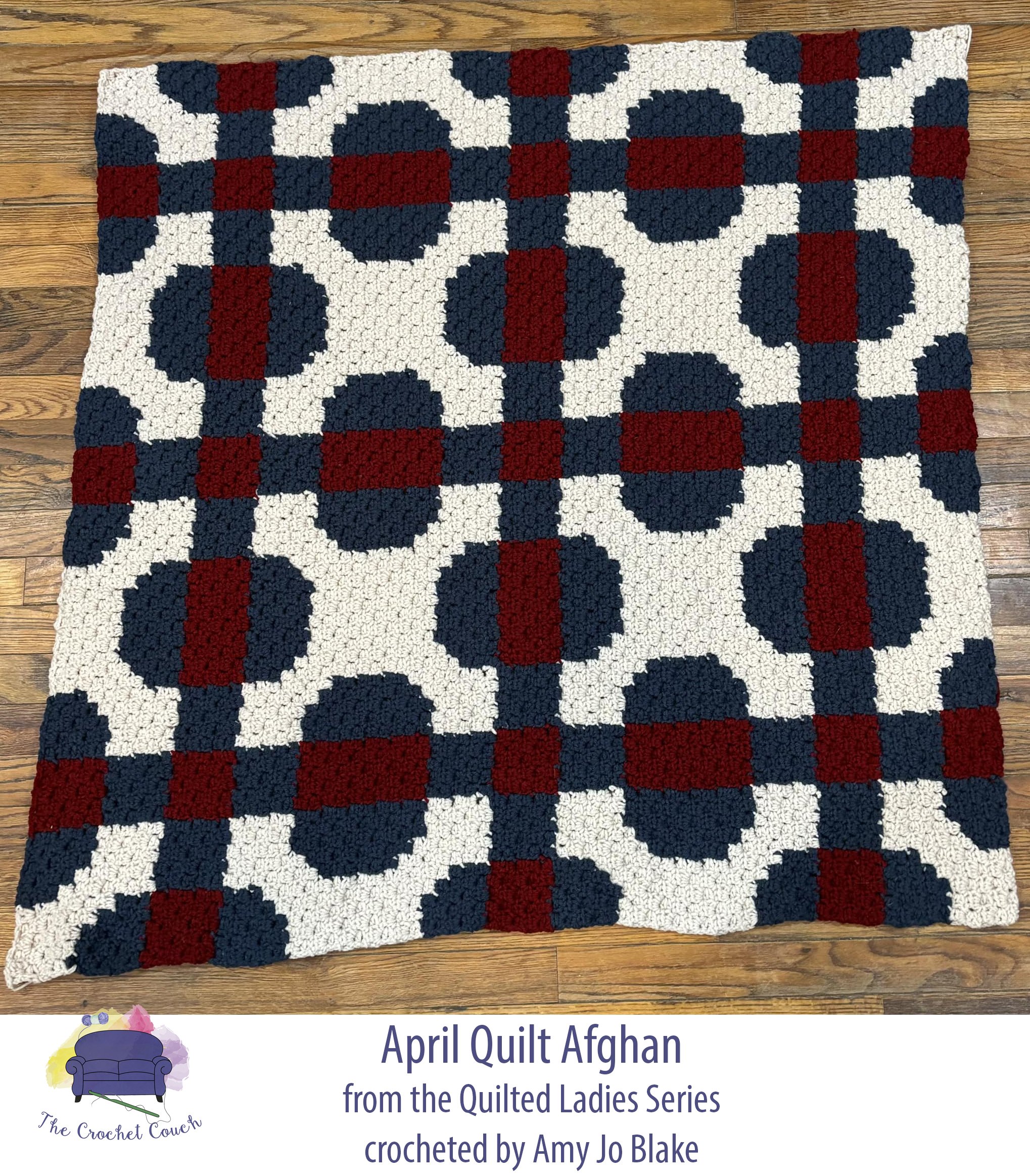 Crocheted quilt afghan laid on wood floor.  Afghan is done in navy, burgundy and white