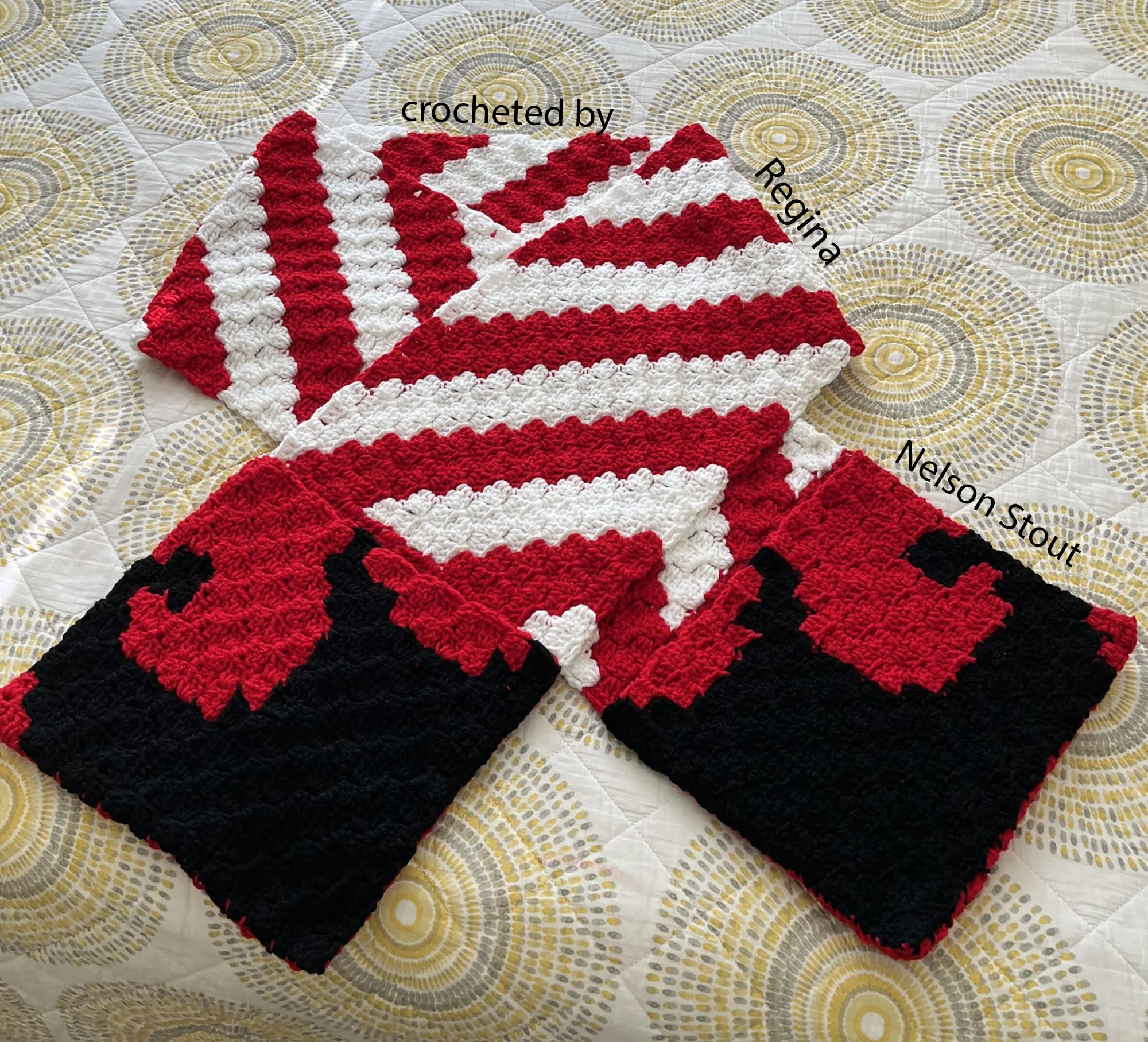 Photo shows a crocheted scarf with pockets..  The pockets have an elf boot on each pocket and the scarf body is red and white stripes.