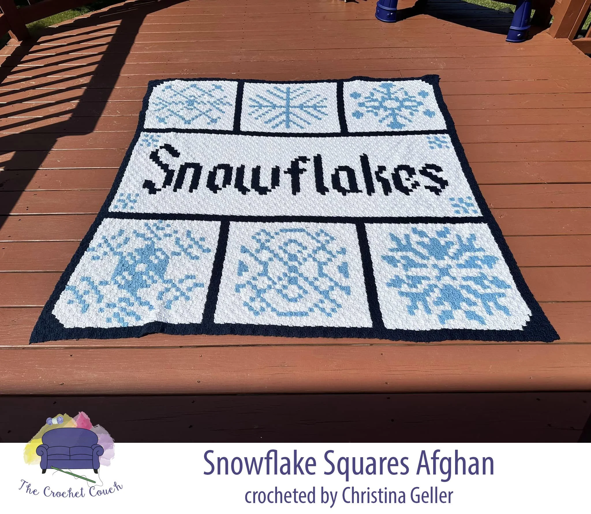 Crocheted afghan shown laid on outside deck, has 6 squares of snowflakes and a big center rectangle with the word Snowflakes.  Afghan is done in white, blue and navy and crocheted by Christina Geller