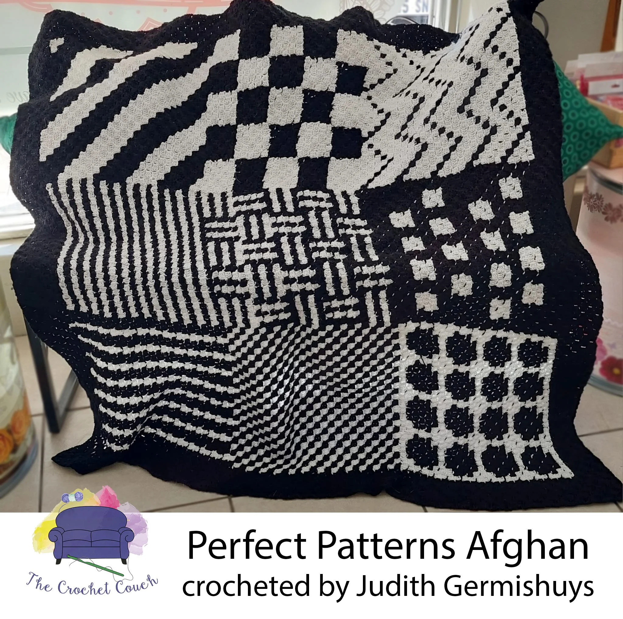 Crocheted afghan done in C2C, shown draped over a chair and shows 9 squares, each with a different black and white pattern.  The border is a solid black  Afghan was crocheted by Judith Germishuys