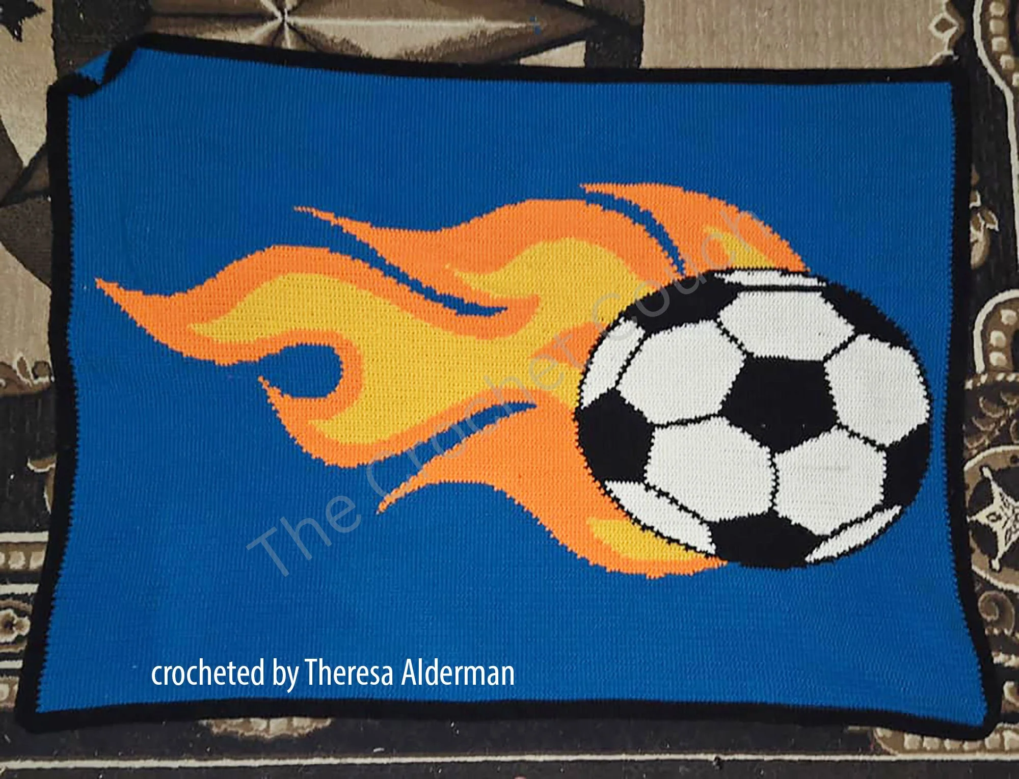 A vibrant crochet afghan featuring a flaming soccer ball design.