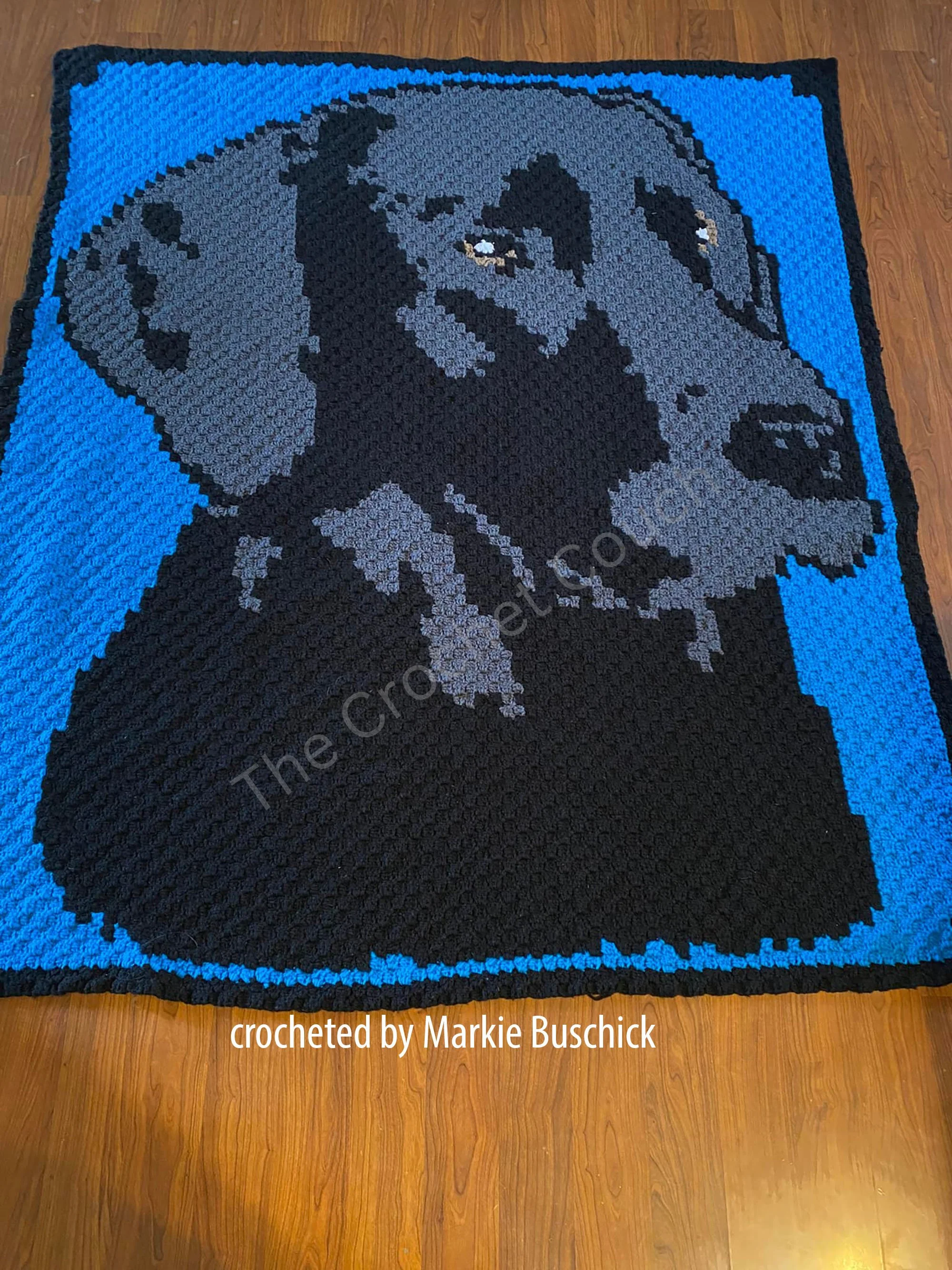A beautifully crocheted Black Lab afghan featuring the side profile of a black labrador on a blue background.