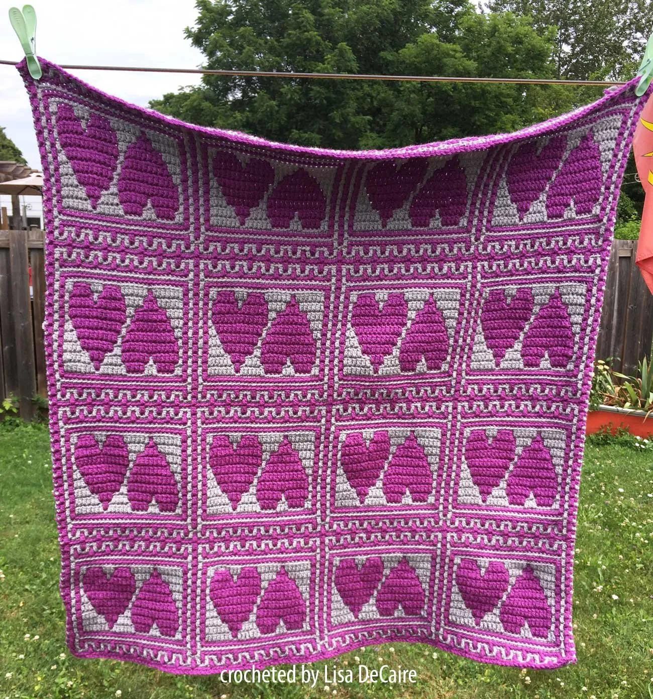 pink and white baby afghan shown hanging from clothesline - hearts done in overlay mosaic crochet by Lisa DeCaire