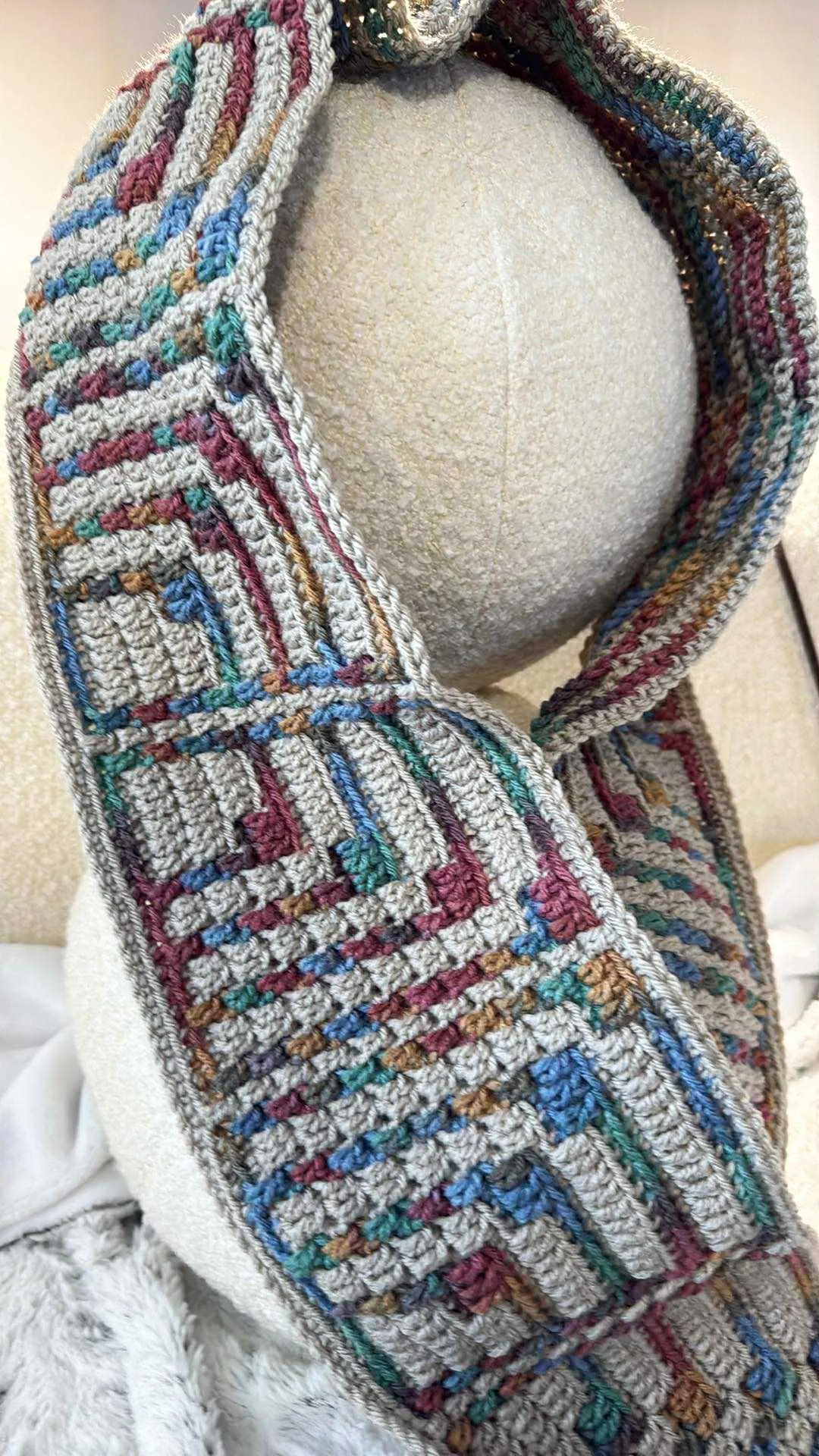 Mosaic scarf done in geometric pattern in hazel and harvest colors - shown on couch, displayed with round pillows