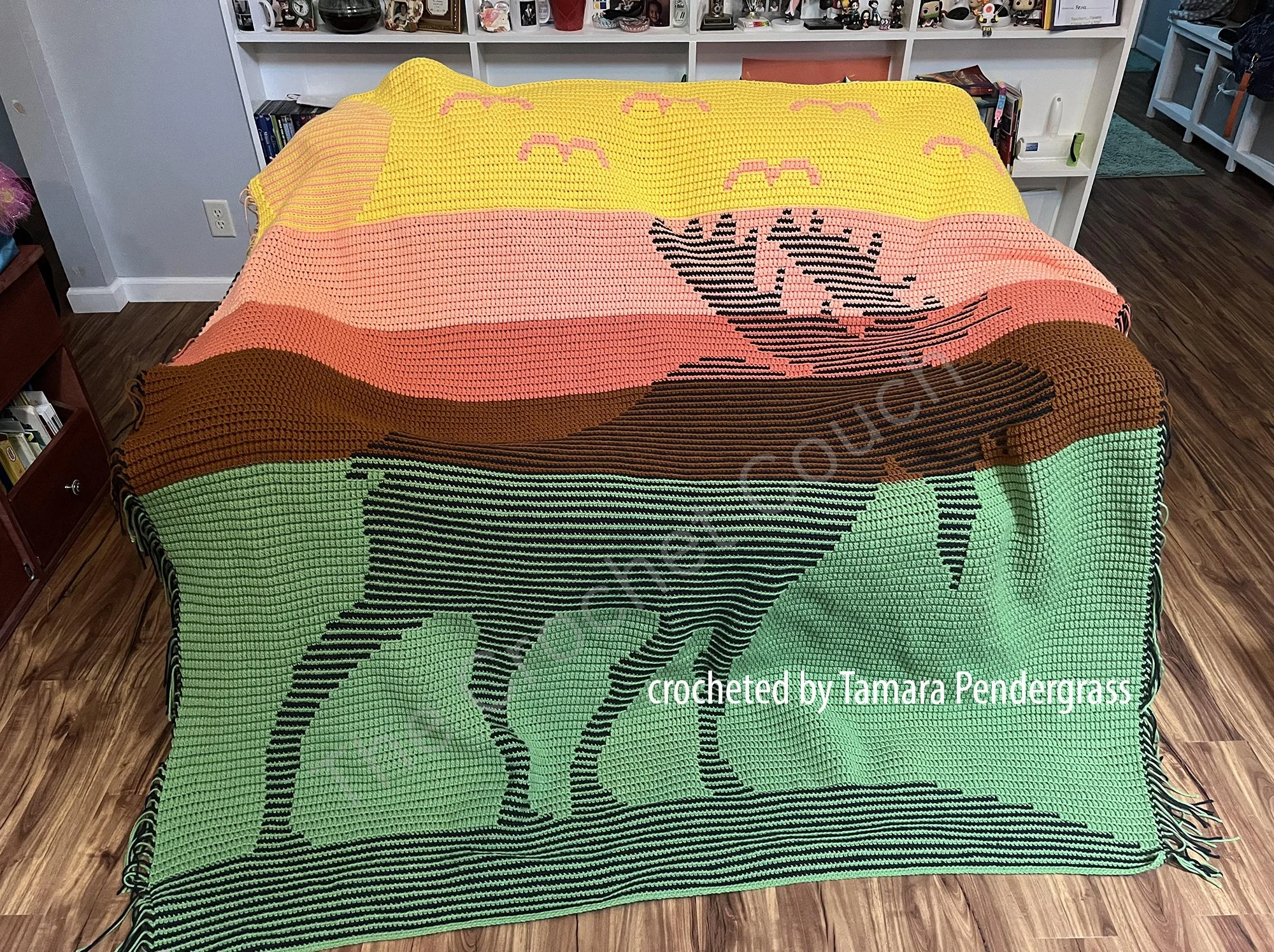 A finished Moose at Sunset Mosaic Crochet Afghan draped over a bed,