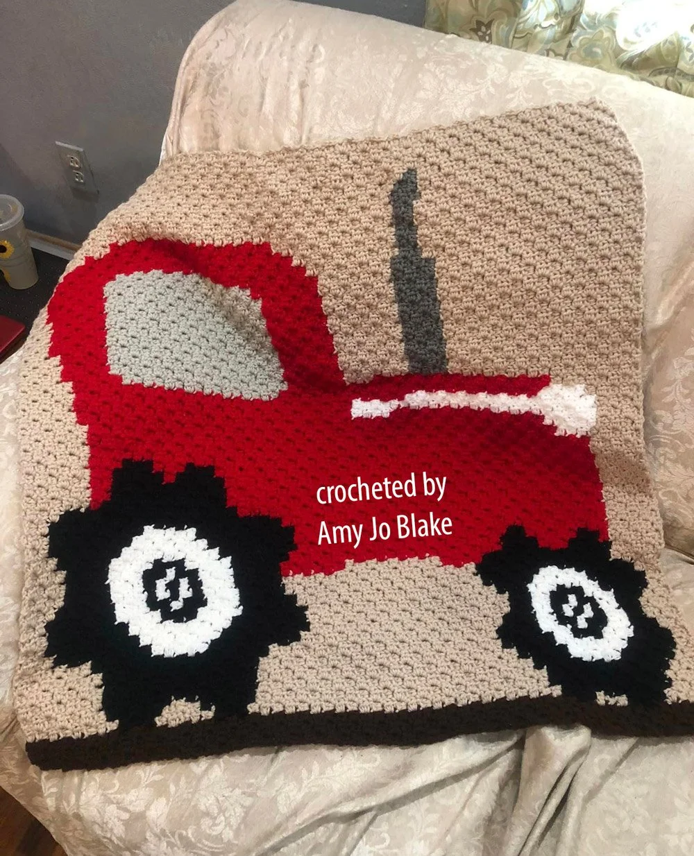 The design features a bright red tractor with black wheels and a soft tan background