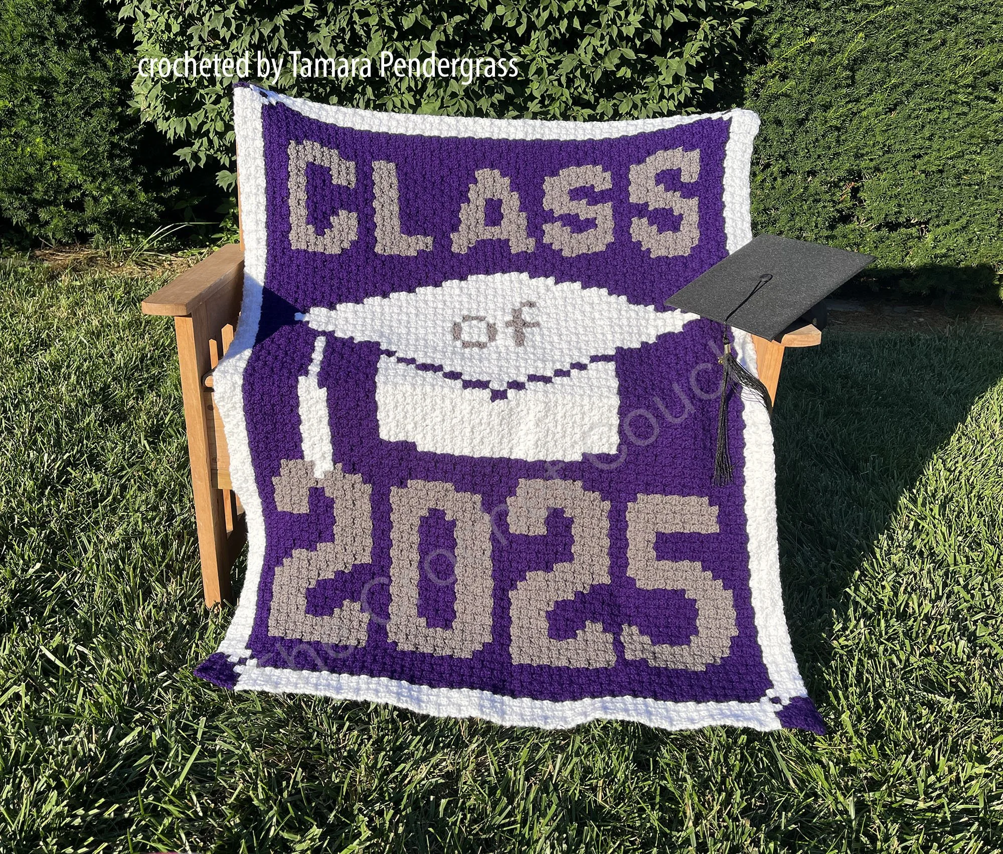 A crocheted afghan featuring "Class of 2025" in bold purple and beige letters