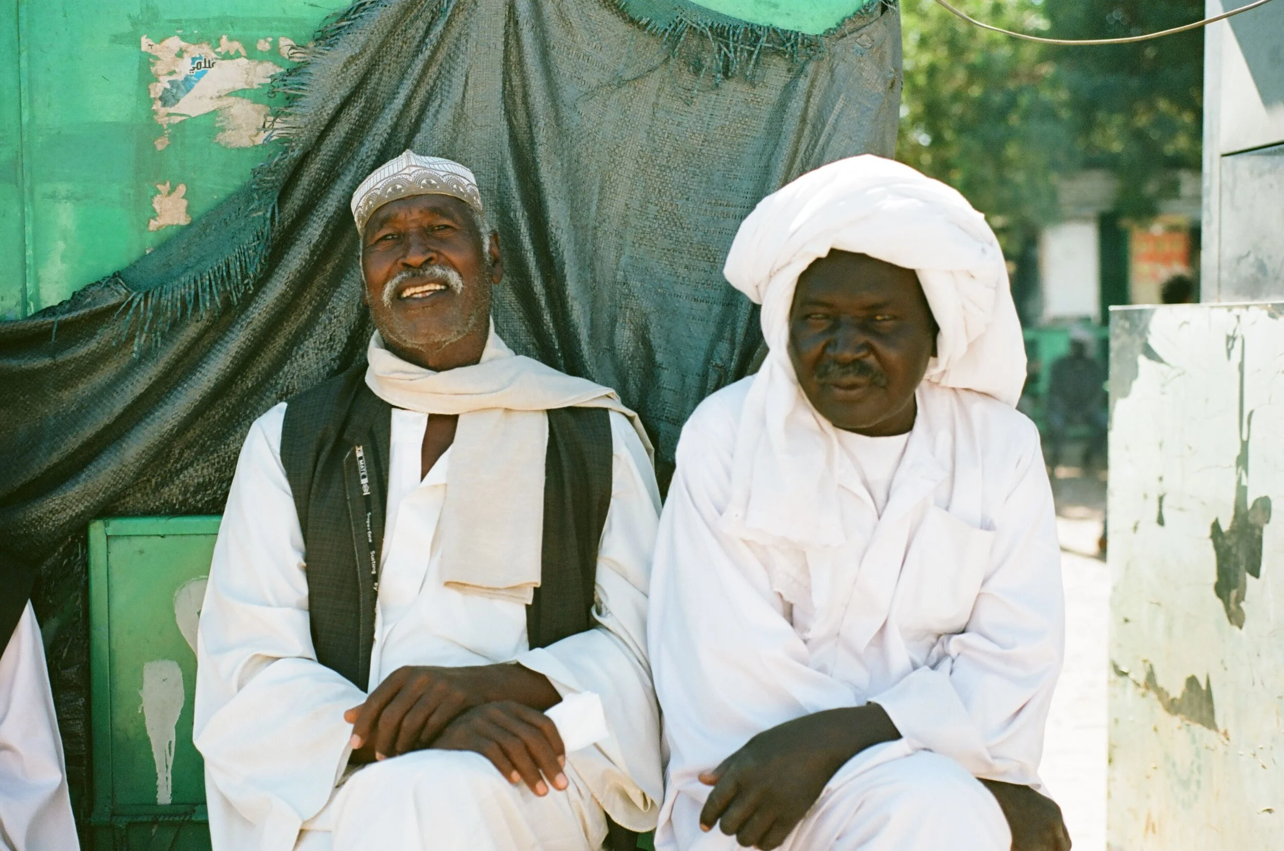 Men Pose for a photo at a bus stop in Dongola Sudan. Kodak Ektar 100.