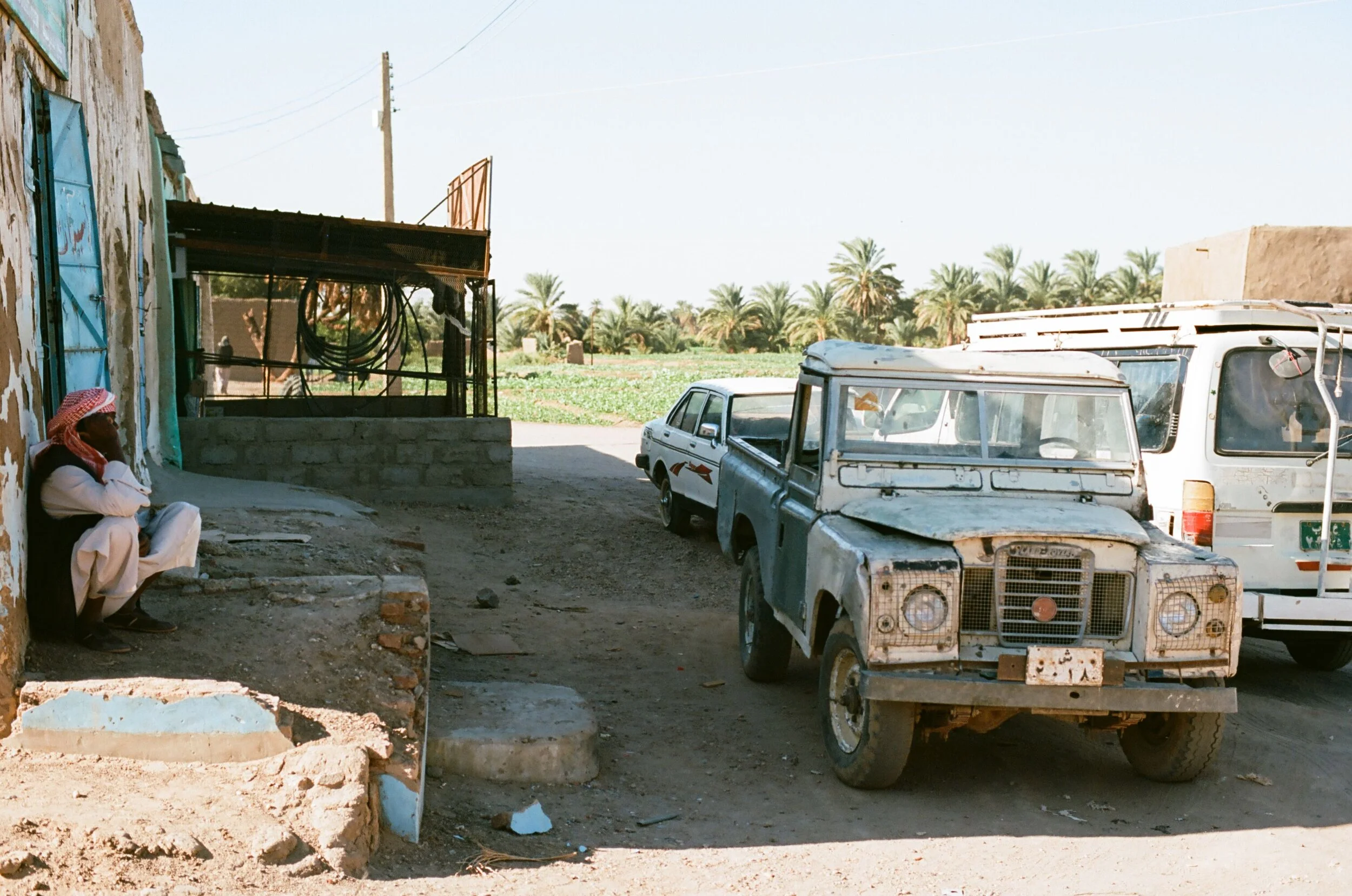 A man resting on a street corner in Abri Sudan. Kodak Ektar 100.