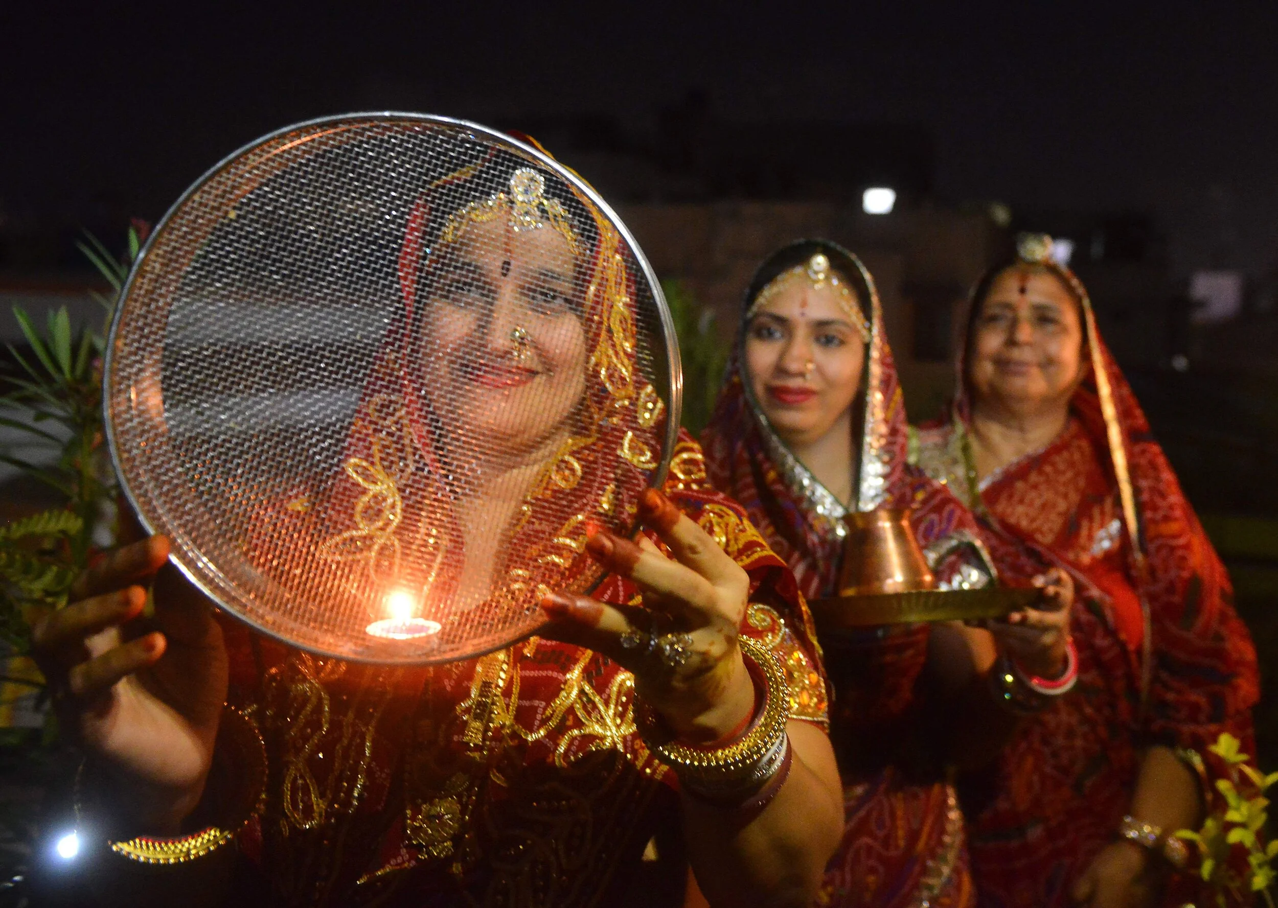 Women dressed in wedding reds for karvachauth. Image Credits: Unrealistic Trends Blog