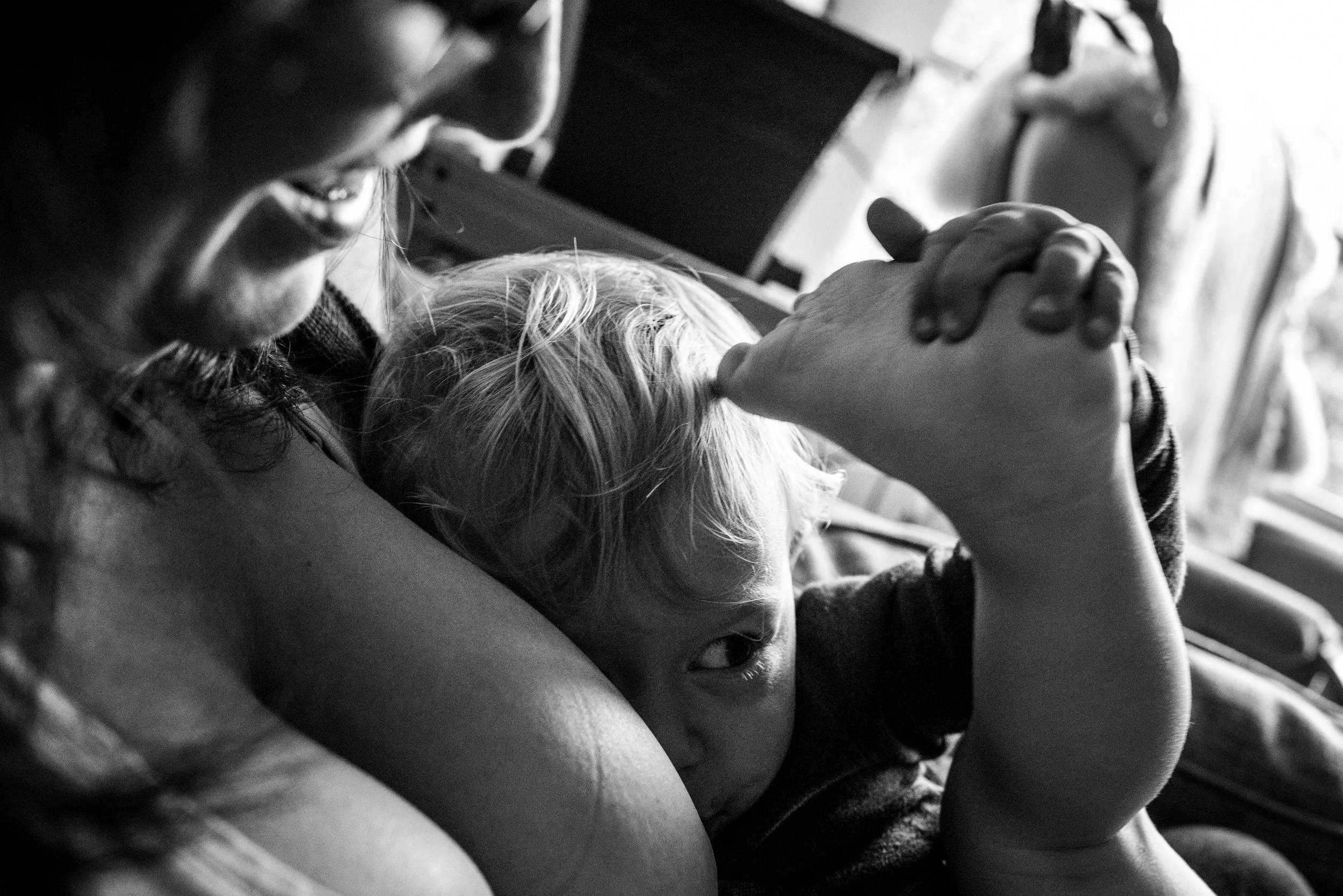 Toddler boy touching his toes to his head while breastfeeding.