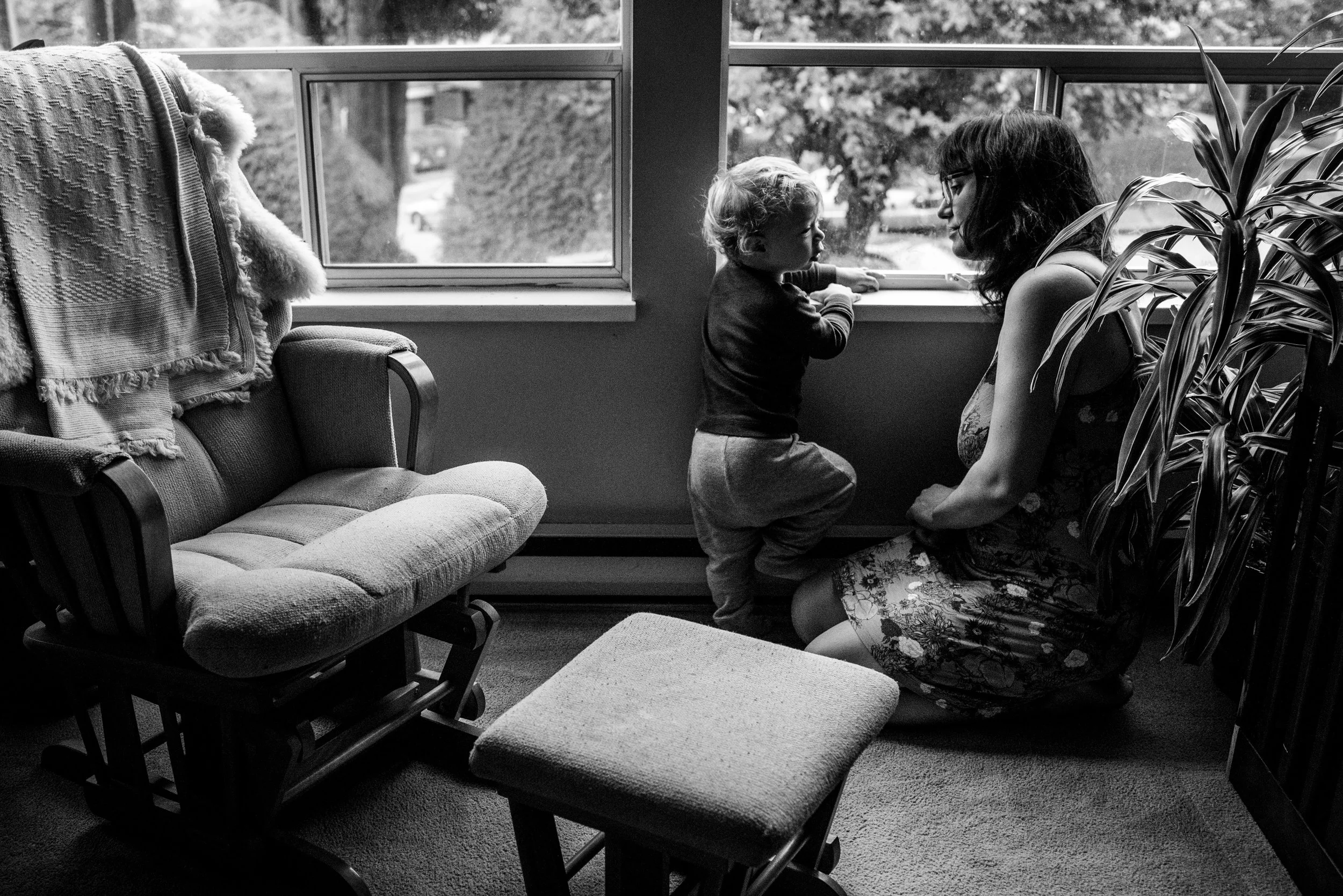 Mom and Toddler boy sharing a quiet moment by the living room window.