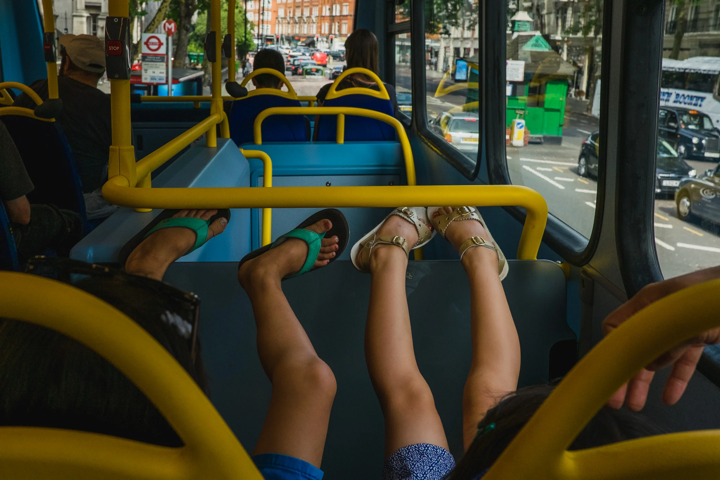 Vacation family photographer. Sisters riding the upper deck of a London bus in the city.
