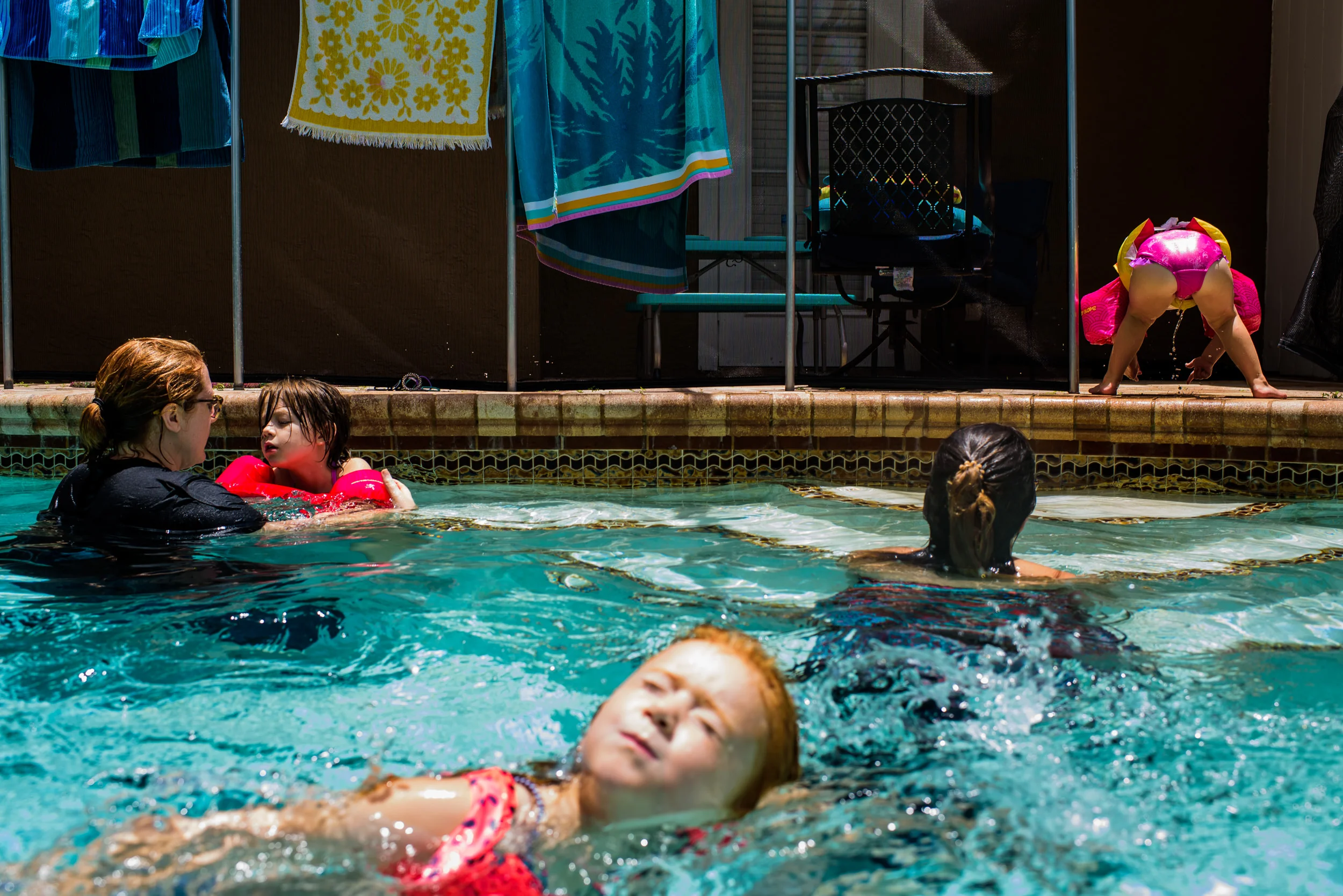 Day in the Life Travel Photographer. Family and friends swimming in the pool at home.