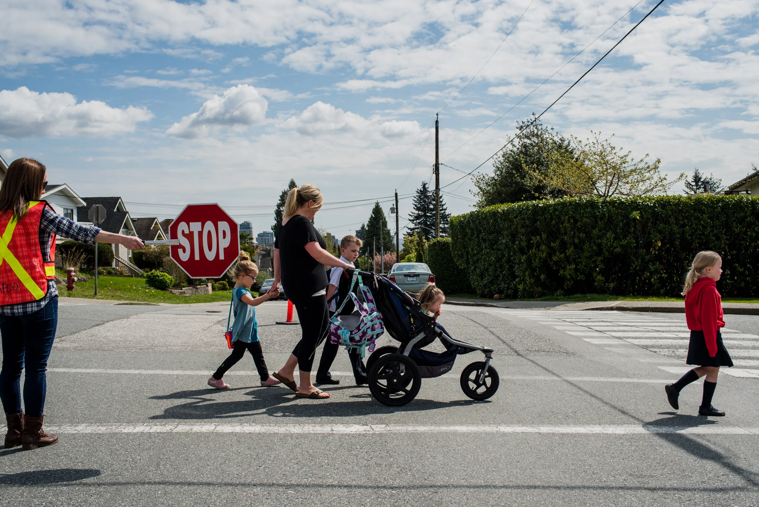 Day in the life of families. A family of four kids walks to school in the morning.