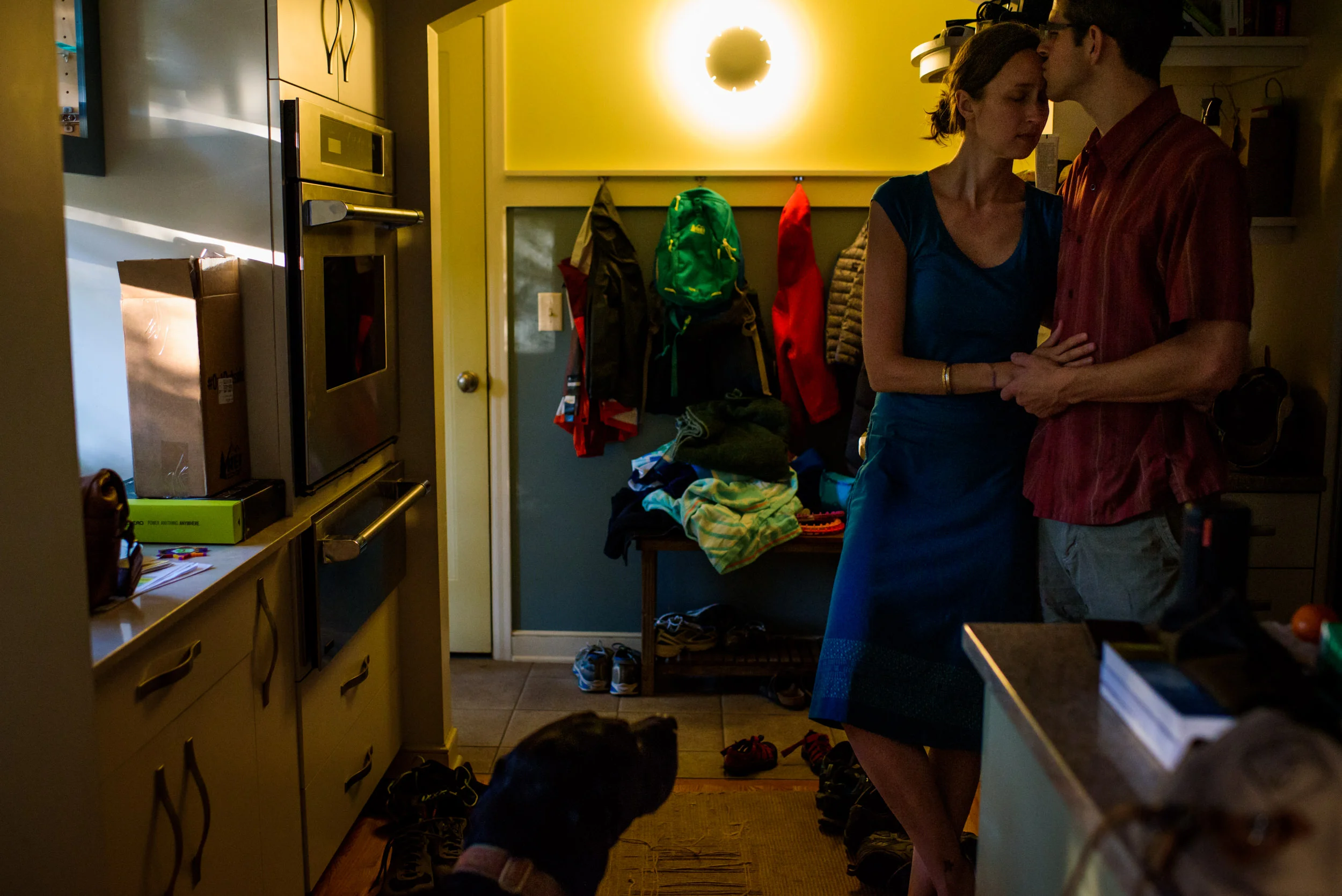 Everyday photos. Parents giving each other a hug at the end of the day with their sons.