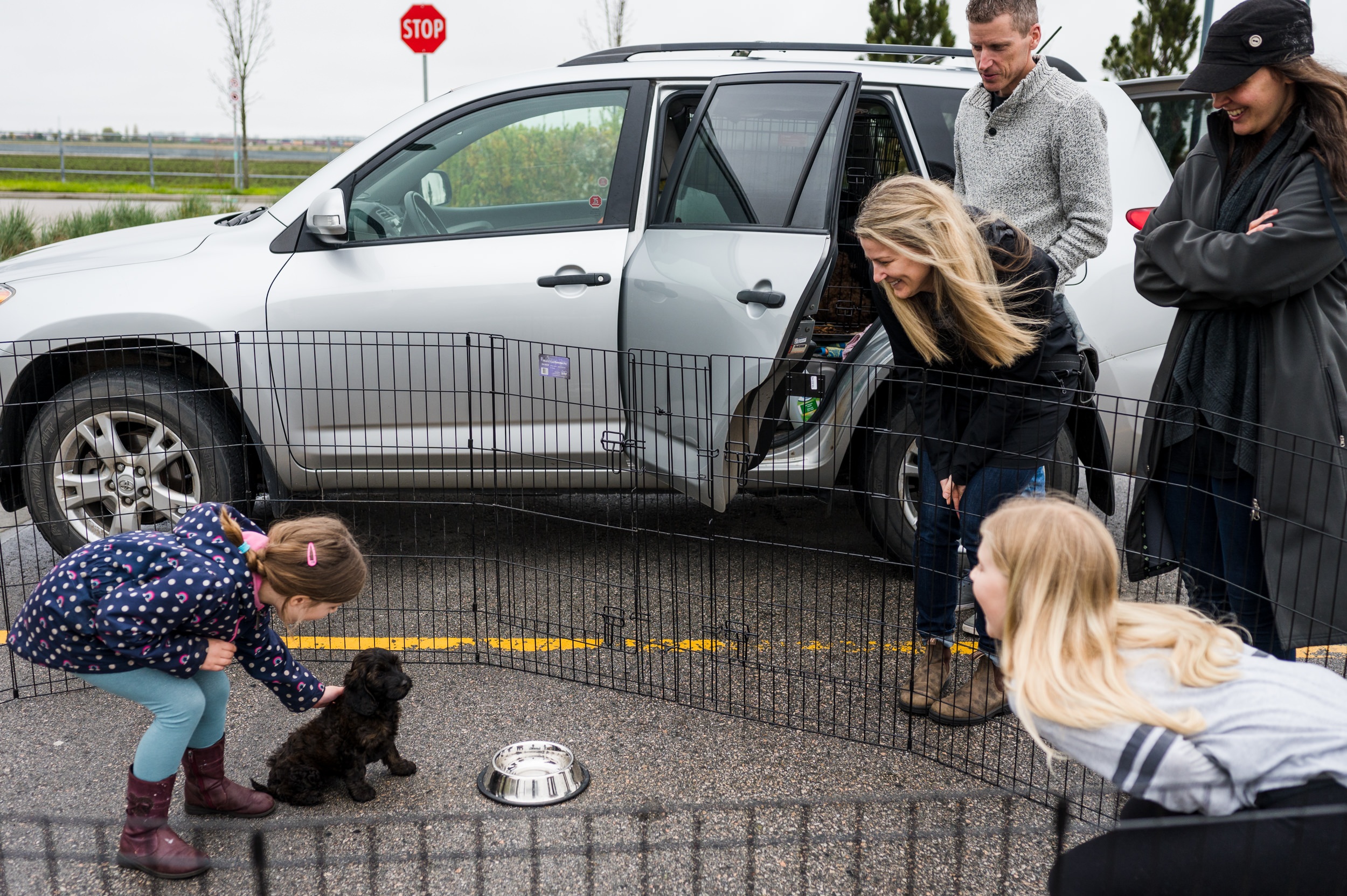 family meeting their puppy for the first time in a parking lot
