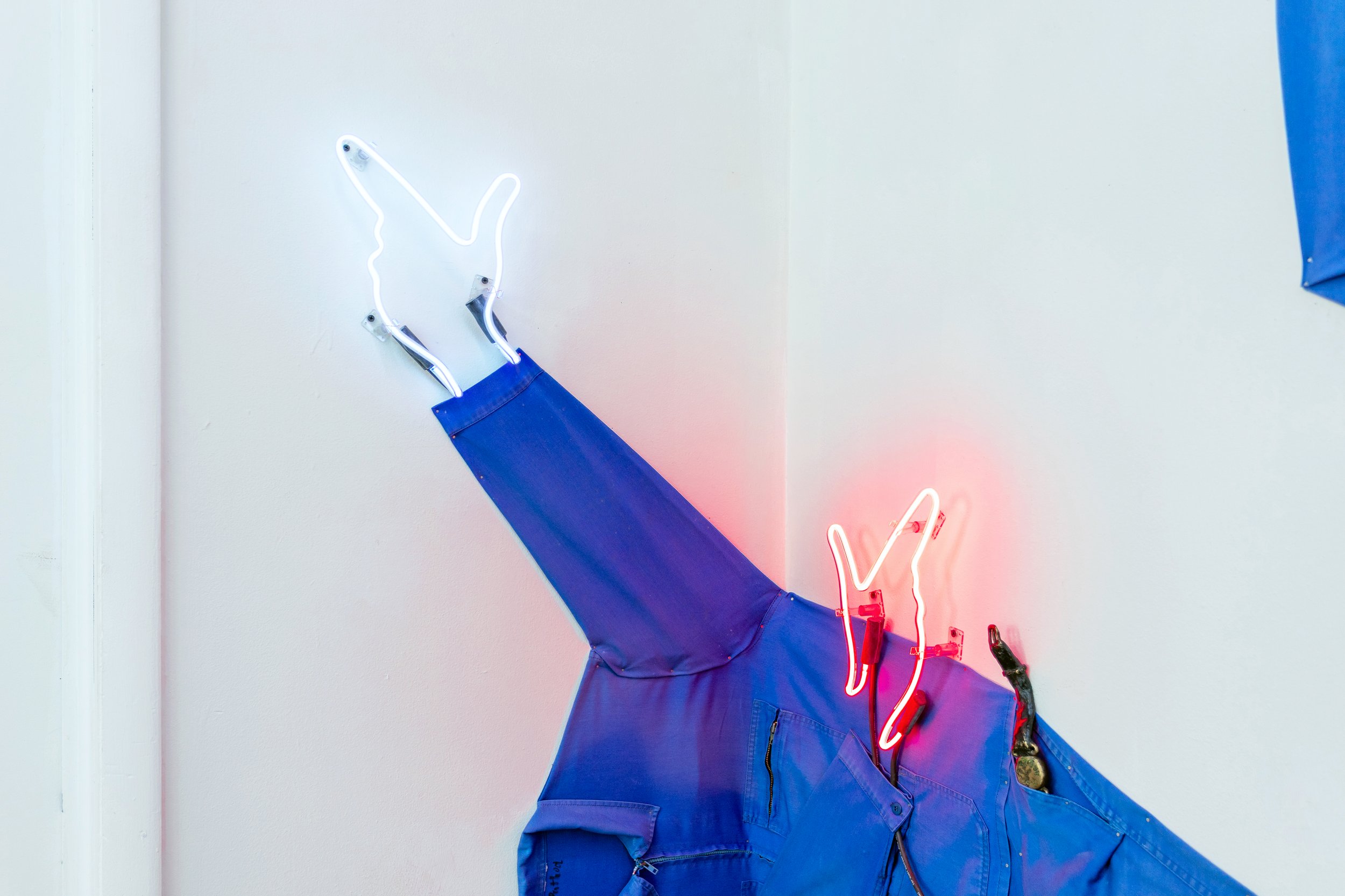 Liliane Puthod , work wear blues, with integral sleeve (detail), 2025. Workwear uniforms, bronze cast, aluminium cast, rivets, keyrings, nails, cables, neon on loan from Jacob Fishman and Zoelle Nagib, Lightwriters Neon Inc. Courtesy the artist.