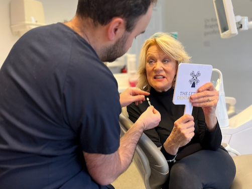 Patient looking into a mirror during a dental appointment at The Lytham Dental Clinic.