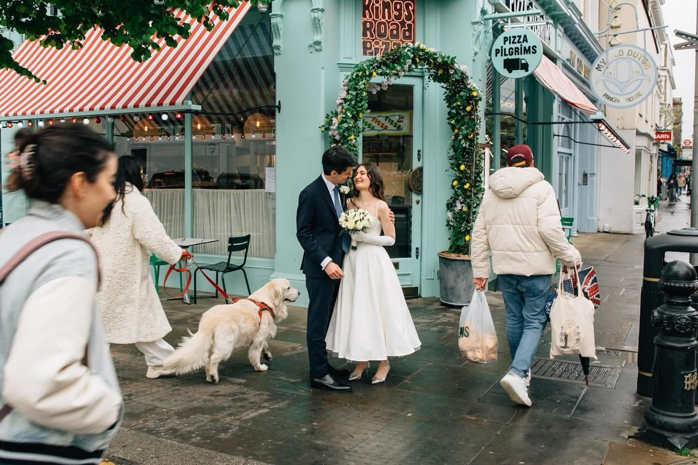 A kiss outside a shop, just married at The Old Chelsea Town Hall, still buzzing from the joy, they paused not for the camera, but for each other. Rebecca &amp; Giacomo❤️❤️
⁠
London didn&rsquo;t stop. Dogs passed. Strangers wandered. Life kept moving.