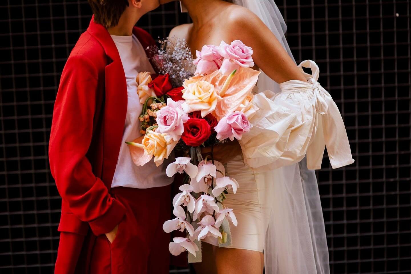 There&rsquo;s something I absolutely love here!  the red suit, the gorgeous mini dress, the bright bouquet, and this moment of love between them in the middle of a busy, busy London.

It&rsquo;s bold and creative, two brides bringing their own style 