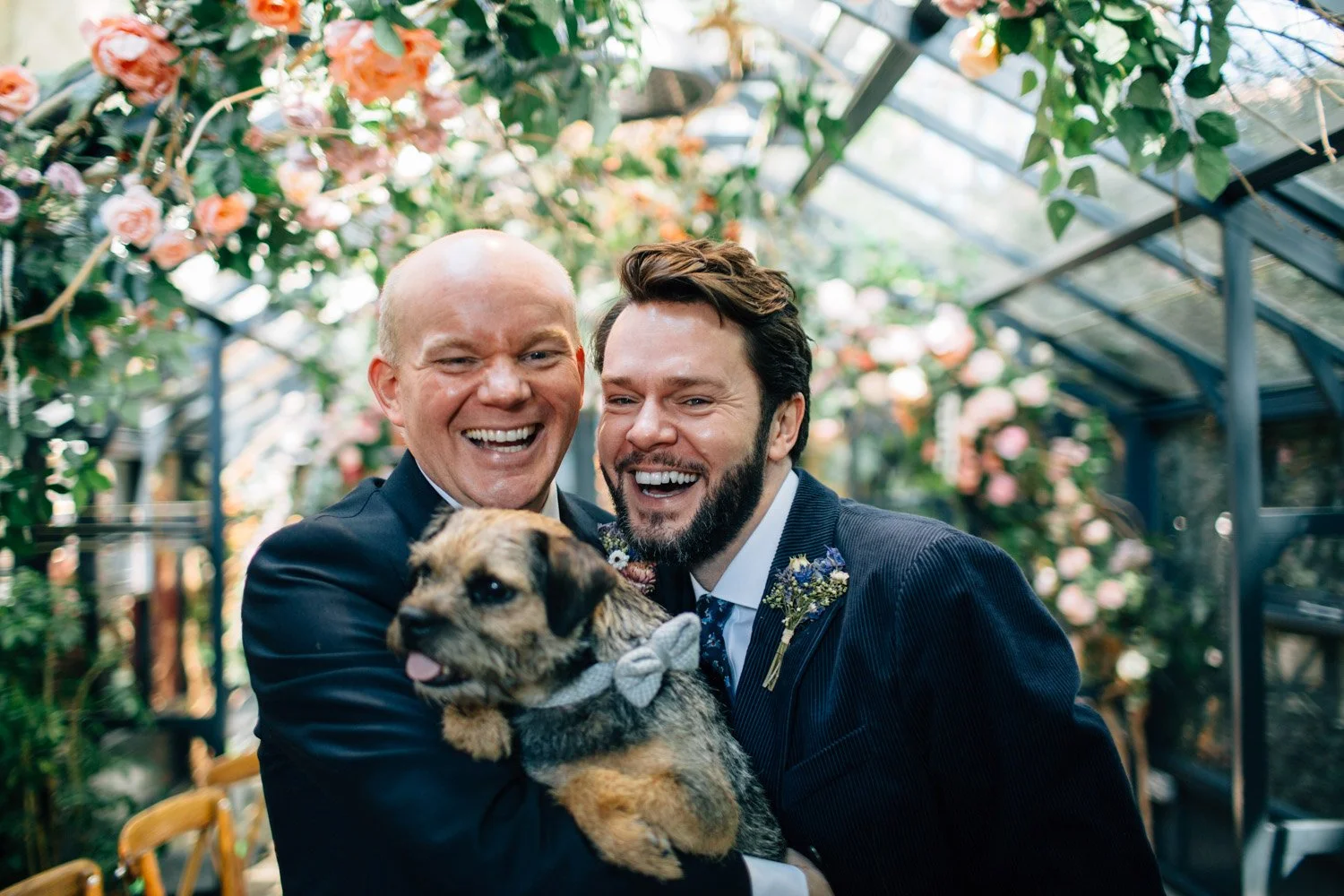 Happy couple with their dog surrounded by greenery at The Greenhouses in Marylebone
