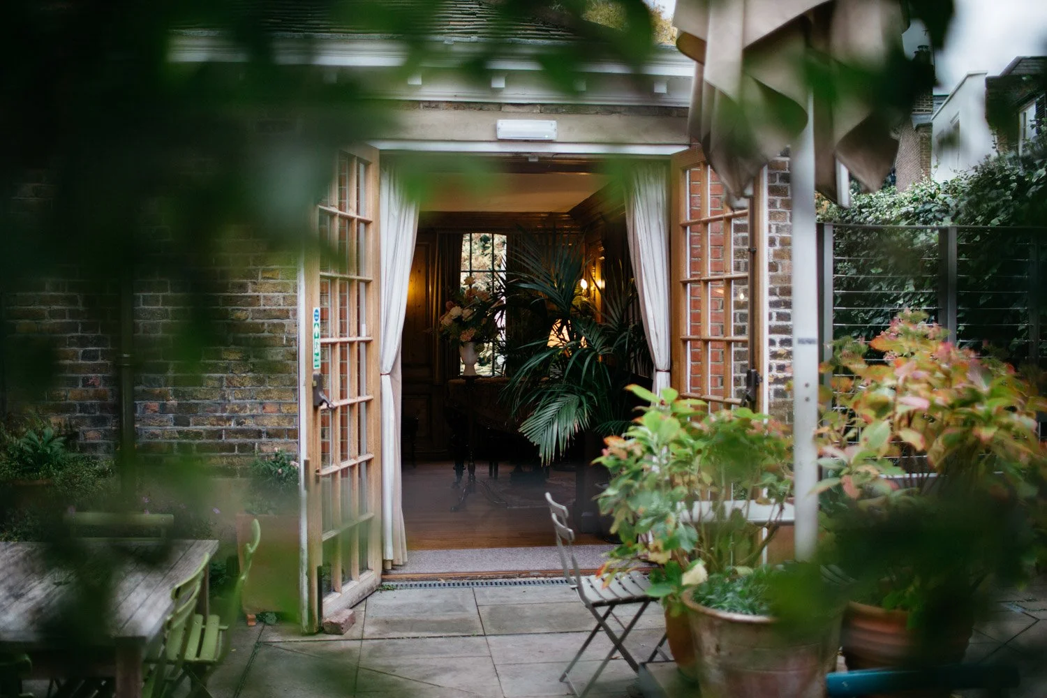 View through the leafy garden towards the entrance of Burgh House in Hampstead