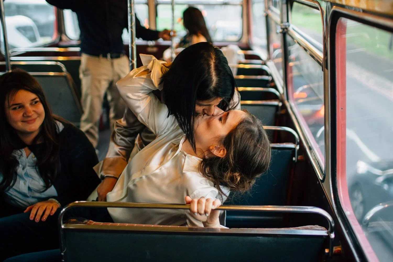 Two brides kissing on a London bus