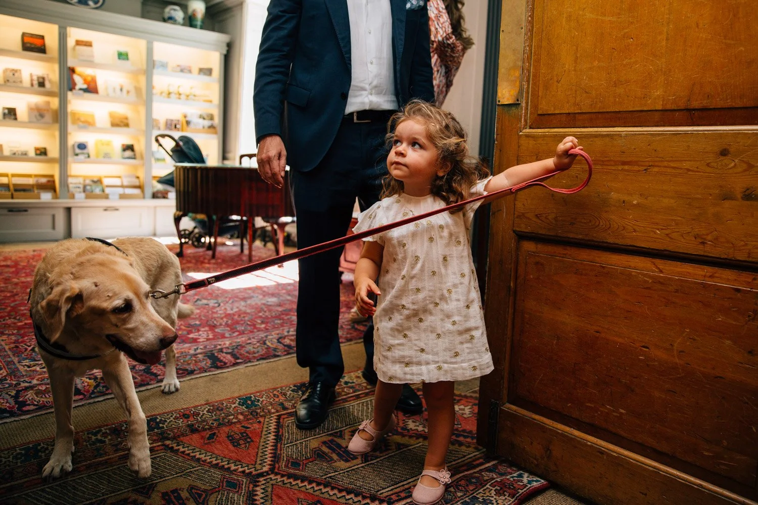 Child walking a dog during a relaxed wedding celebration at Burgh House