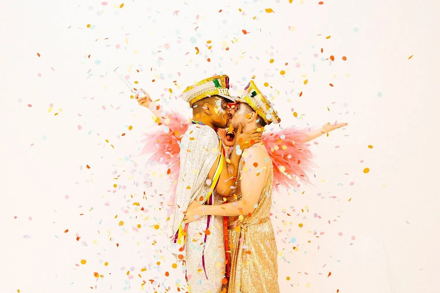 LGBTQ+ wedding couple celebrating with confetti