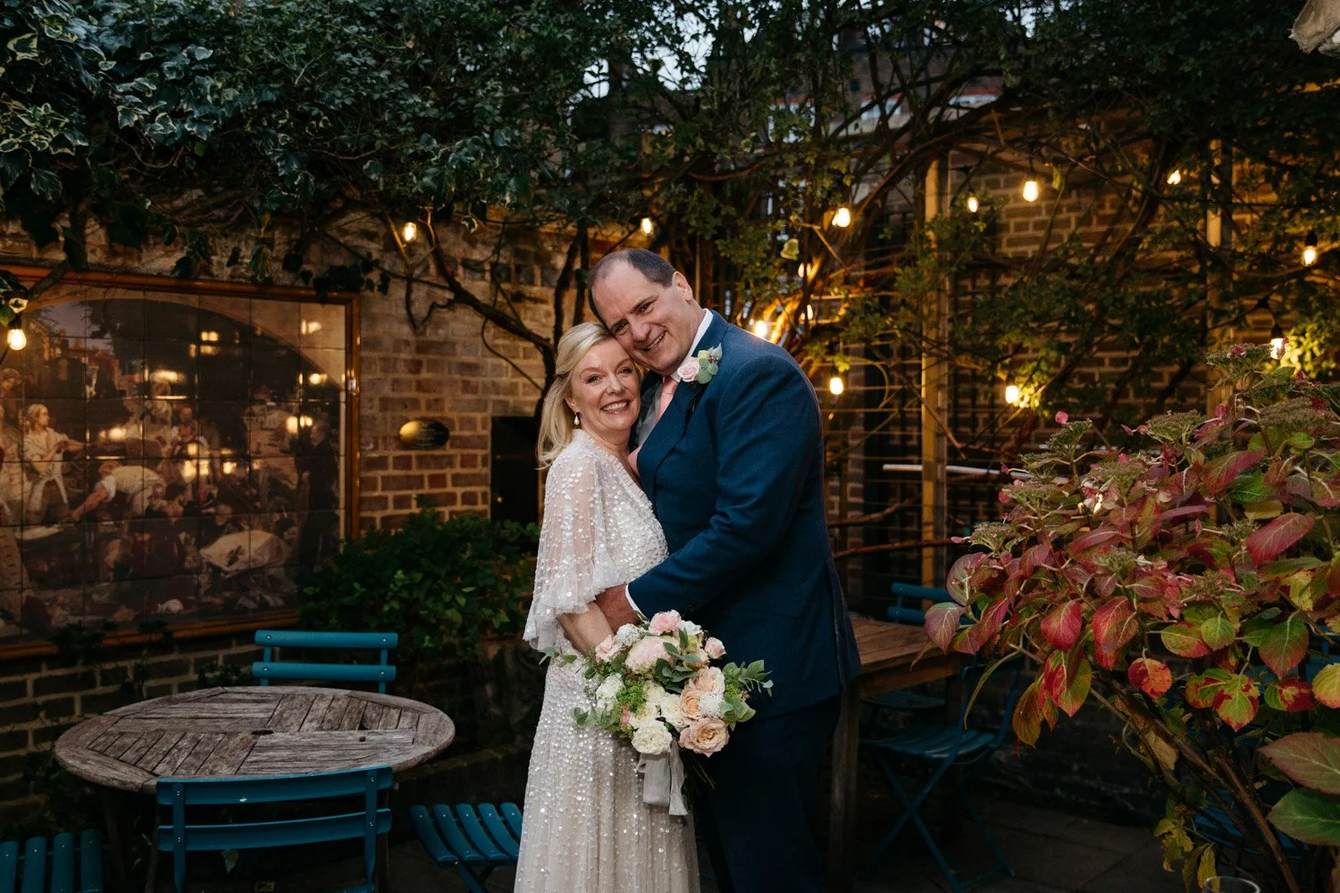 Newly married couple embracing in the garden at Burgh House in Hampstead