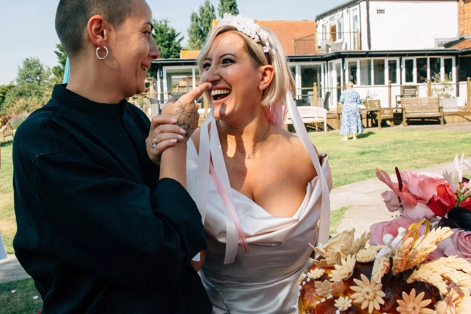 Two brides laughing together on their wedding day