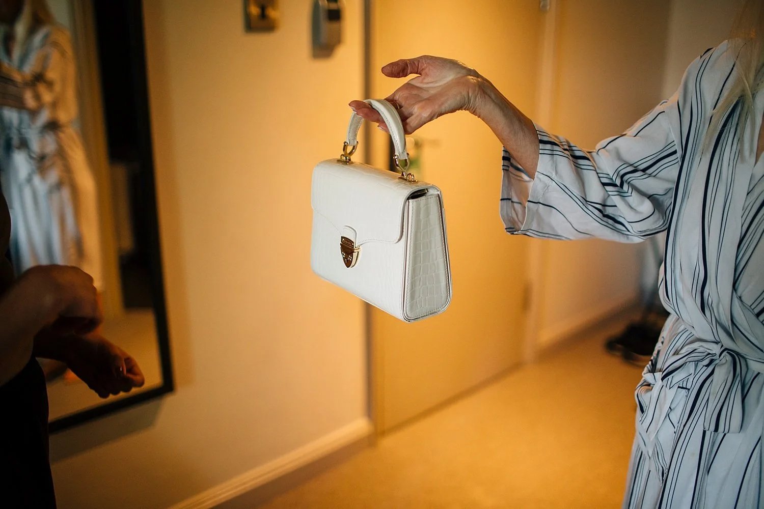 Bride reaching for her handbag while getting ready at The Alexander Pope in Twickenham