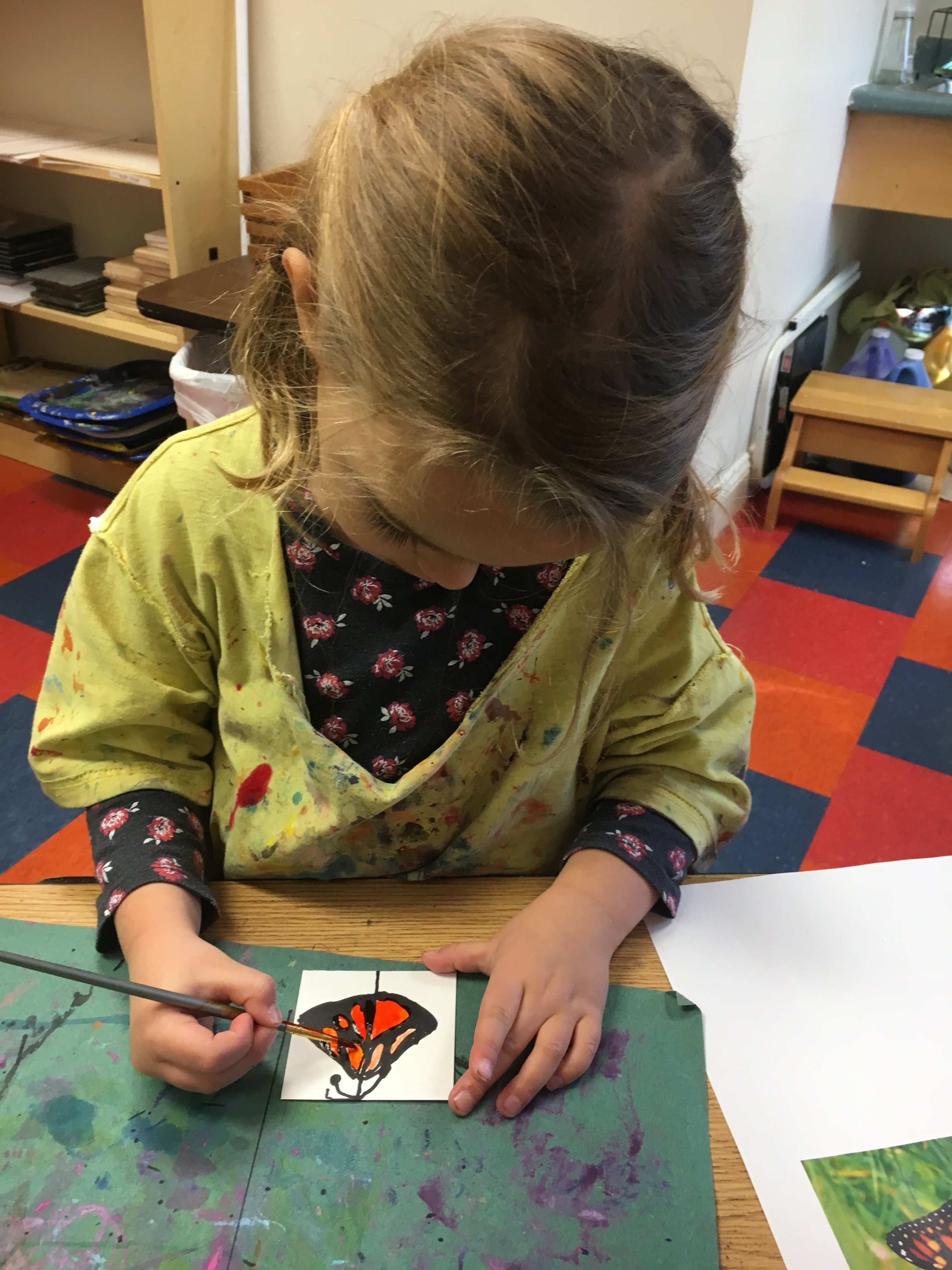  This 4 year old girl uses black sharpie and water color paints to create a Monarch butterfly in the art studio. 
