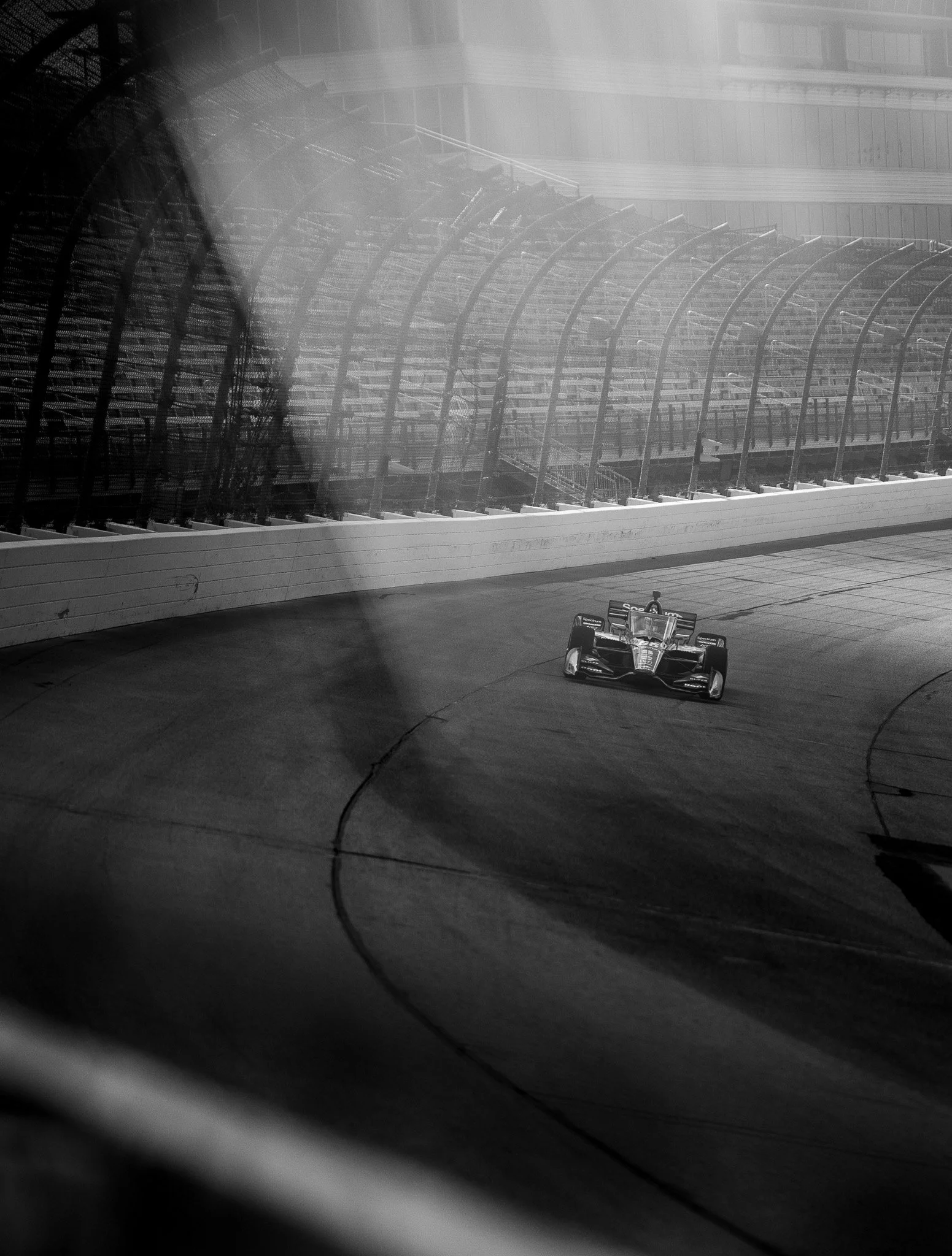 Black and white photo of Marcus Armstrong's No. 66 Meyer Shank Racing Honda navigating the empty Iowa Speedway during the June 2025 team test.