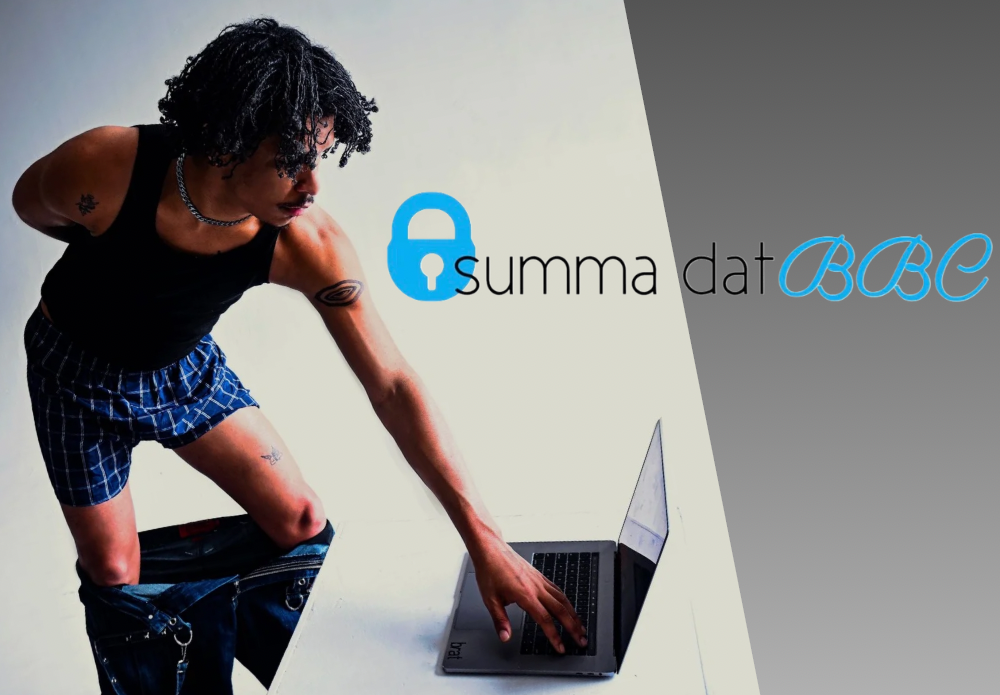 A photo of a black person with twists in a black tank top with their pants pulled down to their knees and blue boxers on. They're typing on a laptop with one hand and the other hand is behind their back. Reads "Summa dat BBC." Click for more info.